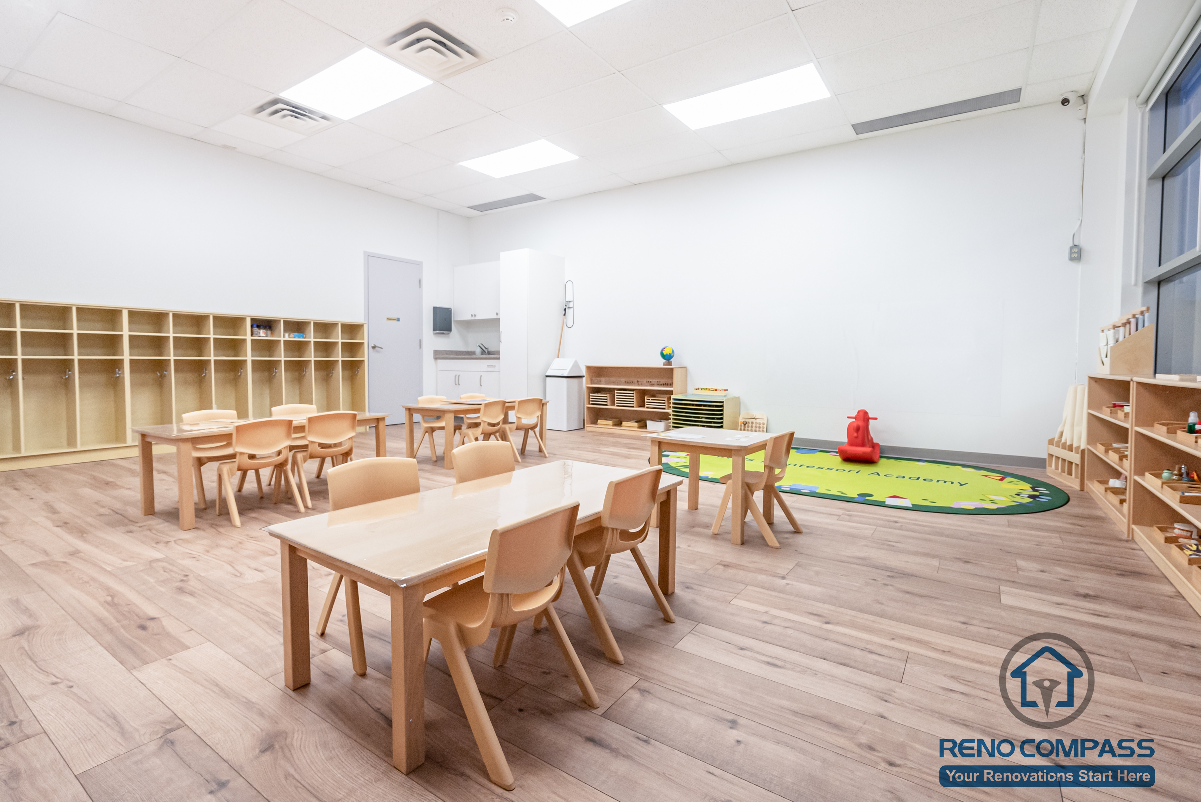 This Markham daycare renovation showcases a spacious classroom learning area designed to support group activities, early education, and daily routines. Child-sized tables and chairs are arranged to encourage collaboration while maintaining clear circulation for supervision. Open shelving and low-height cubbies provide organized storage that promotes independence and easy access for children. Durable, slip-resistant flooring and bright overhead lighting ensure safety, comfort, and long-term usability. Completed by a Toronto renovation company, Reno Compass Inc., this daycare interior renovation reflects a thoughtful balance of educational functionality, safety compliance, and efficient space planning for modern childcare environments.