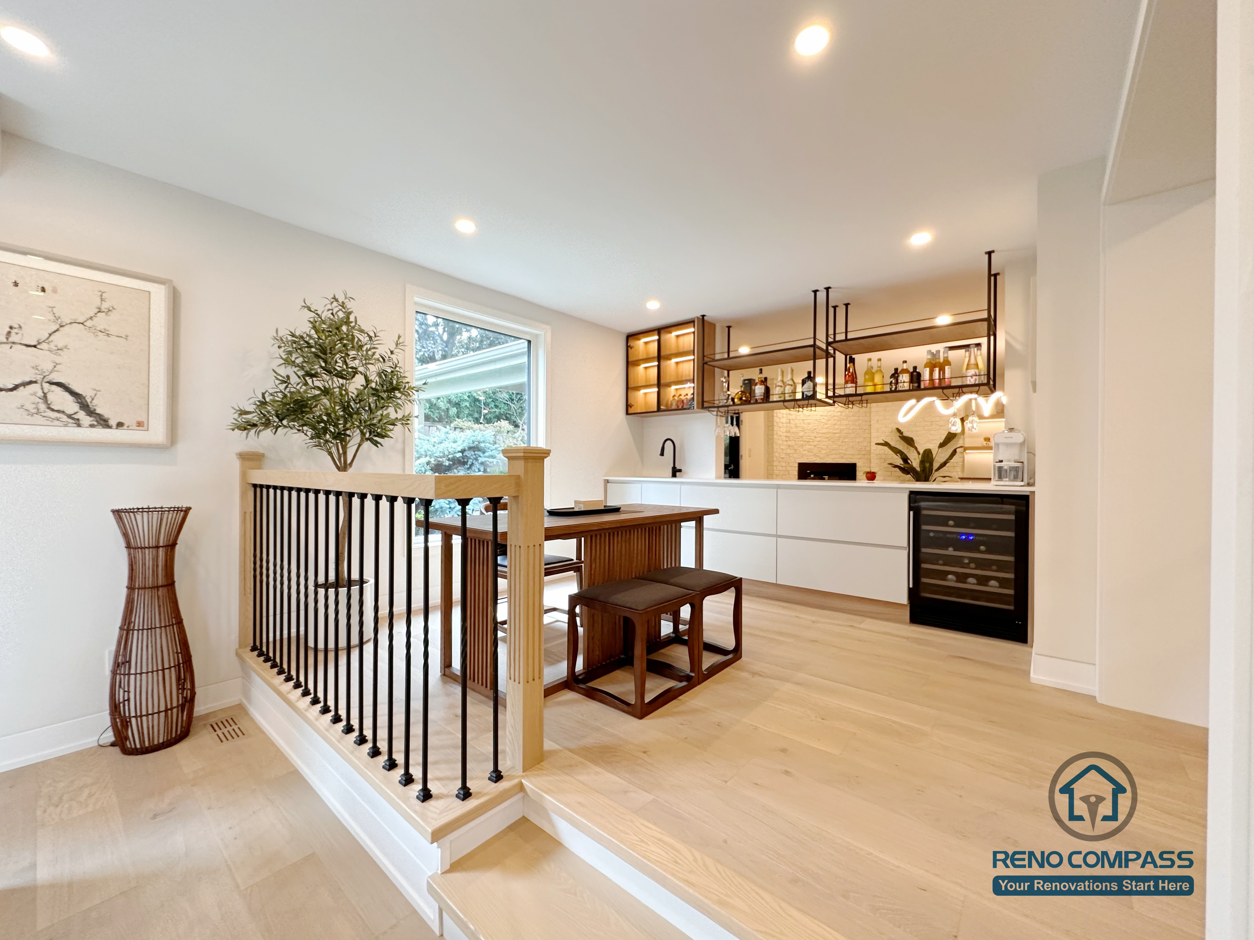 An open-concept kitchen and dining area renovation in Toronto featuring custom cabinetry, a built-in bar and beverage station, and clean-lined storage design. Warm wood flooring, integrated lighting, and seamless circulation create a functional yet elegant living space, completed by a professional Toronto renovation company.