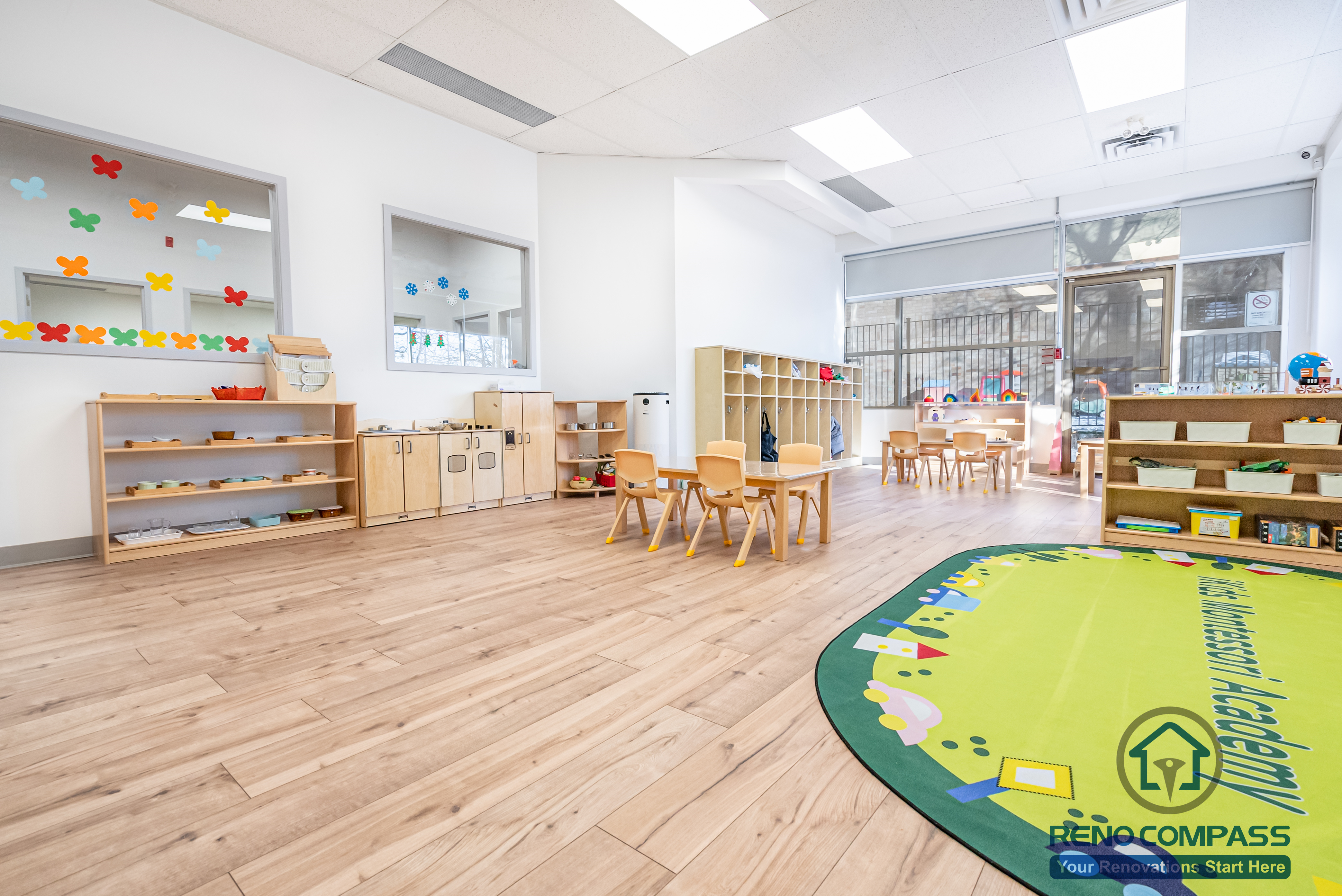 This Markham daycare renovation features a spacious open classroom designed to support multiple learning and play activities within a safe and well-organized environment. The layout provides clear sightlines for supervision while allowing children to move freely between learning tables, storage areas, and soft play zones. Low-height shelving and child-accessible storage promote independence and daily organization. Durable, easy-to-clean flooring and bright overhead lighting enhance safety, comfort, and long-term maintenance. Completed by a Toronto renovation company, Reno Compass Inc., this daycare interior renovation reflects a thoughtful approach to space planning, safety compliance, and functional design for modern childcare facilities.