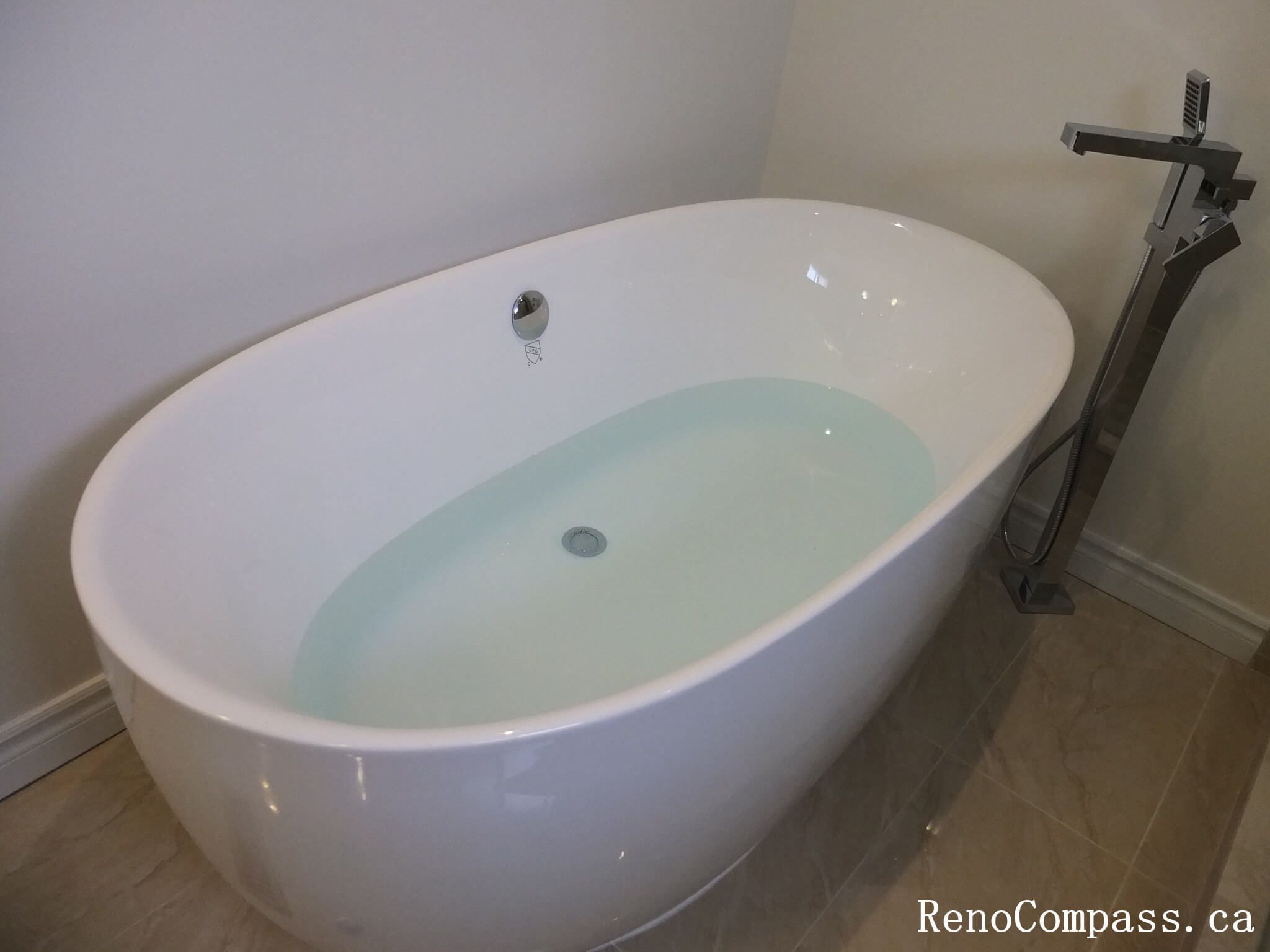 Bathroom renovation in North York featuring a freestanding bathtub with floor-mounted faucet and clean, minimalist layout. This Toronto interior renovation highlights comfort-focused design, smooth circulation, and durable finishes suited for modern residential bathrooms.