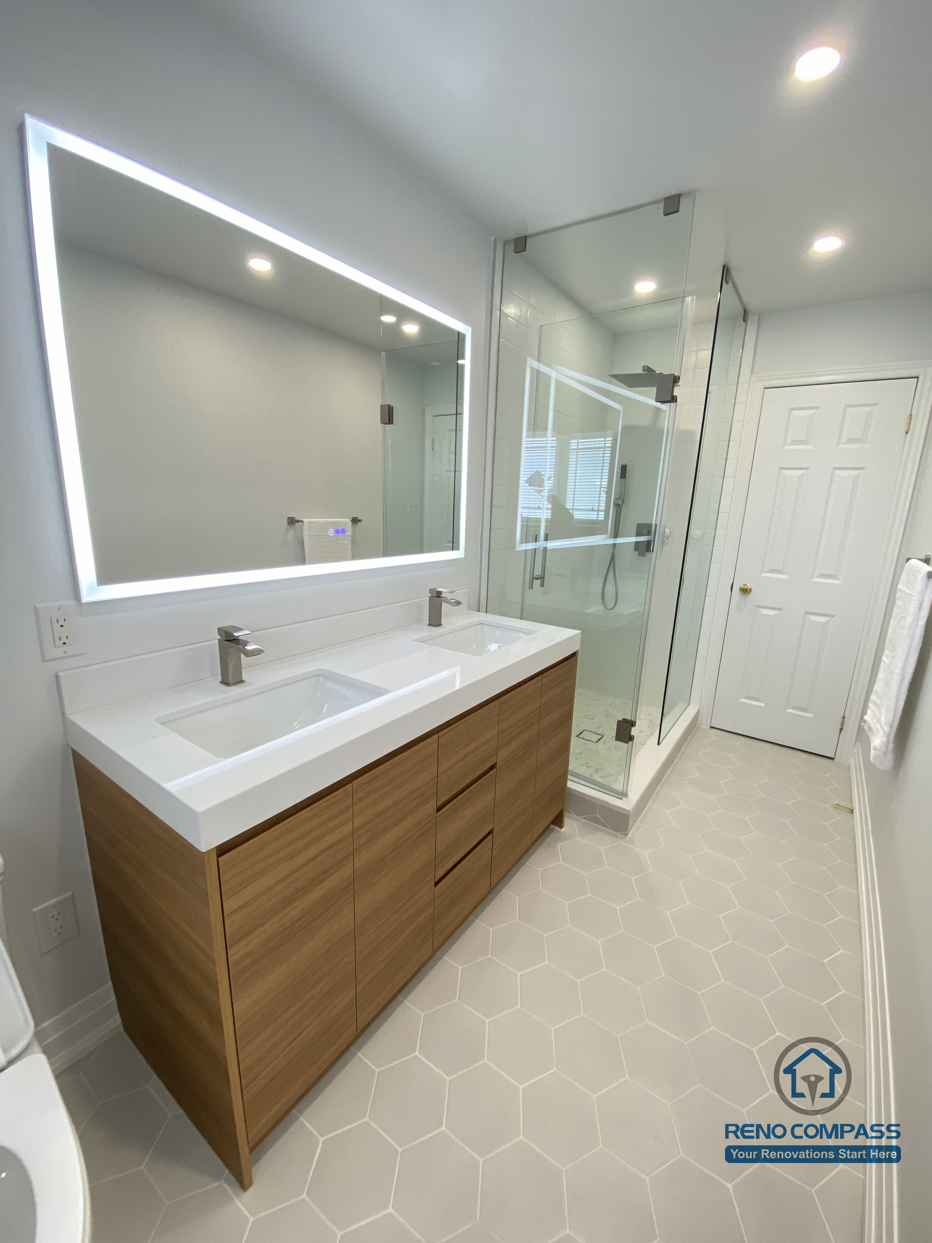 This image highlights a modern bathroom vanity renovation in Markham, featuring integrated drawers, a floating-style wood cabinet, and a sleek LED mirror. The design balances visual warmth with everyday practicality, completed by a trusted Toronto renovation company.