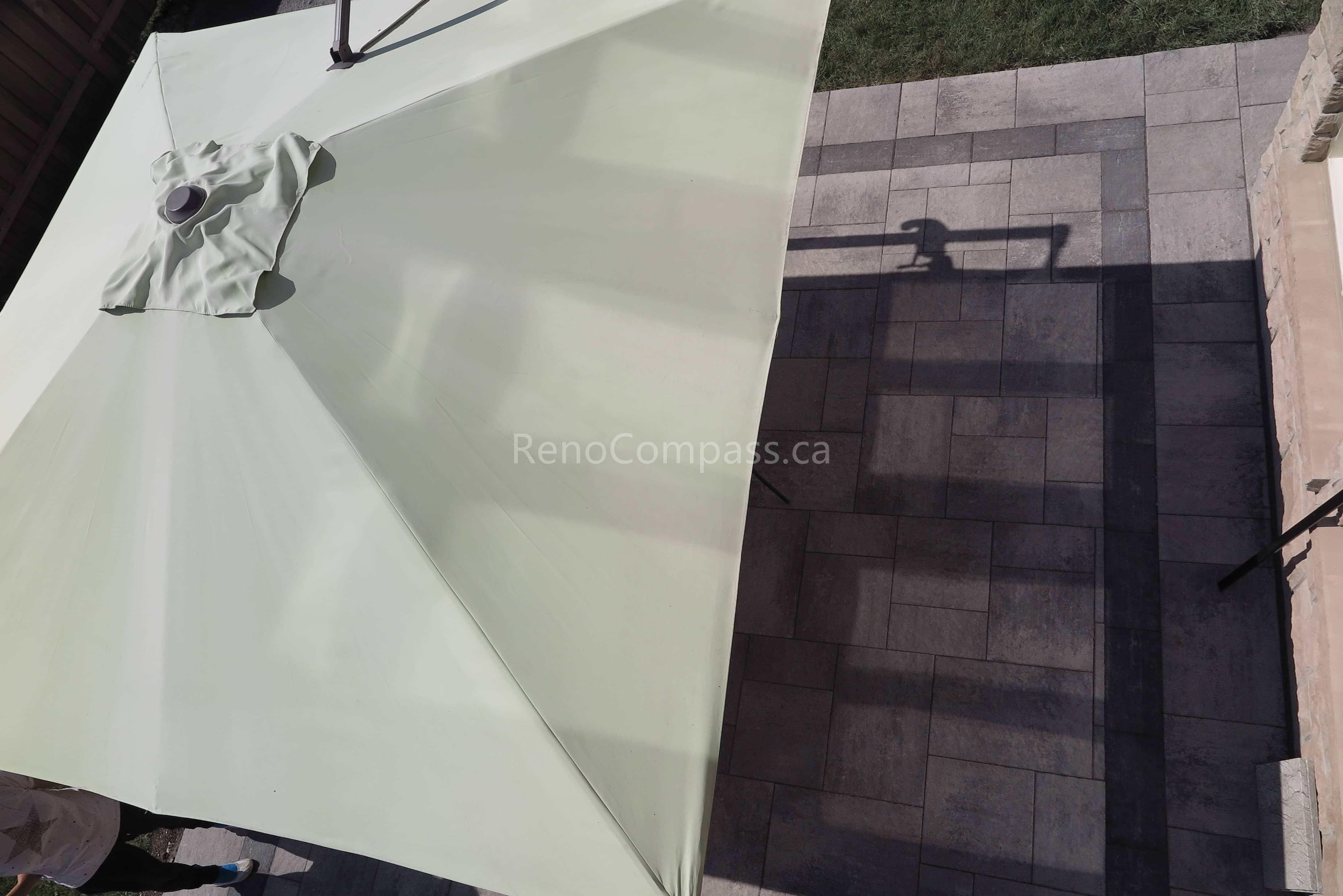This Markham landscaping project showcases a detailed view of the professionally installed interlocking stone patio, designed with a modern geometric layout and contrasting border accents. The outdoor space is enhanced with a large patio umbrella, creating a comfortable shaded seating area for summer relaxation. Built using durable materials for long-term performance and minimal maintenance, this backyard upgrade reflects the quality workmanship of a trusted Toronto renovation company while elevating everyday outdoor living.