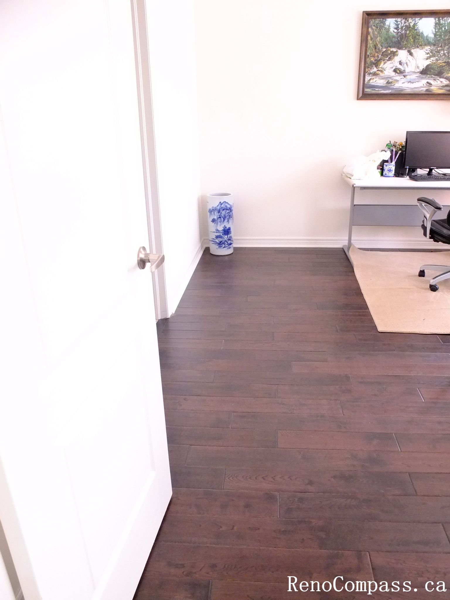 Toronto home hardwood flooring installation featuring deep-toned wood floors throughout the hallway and upper level. This professional flooring renovation enhances brightness, durability, and visual continuity, completed by Reno Compass for a clean and modern interior upgrade.