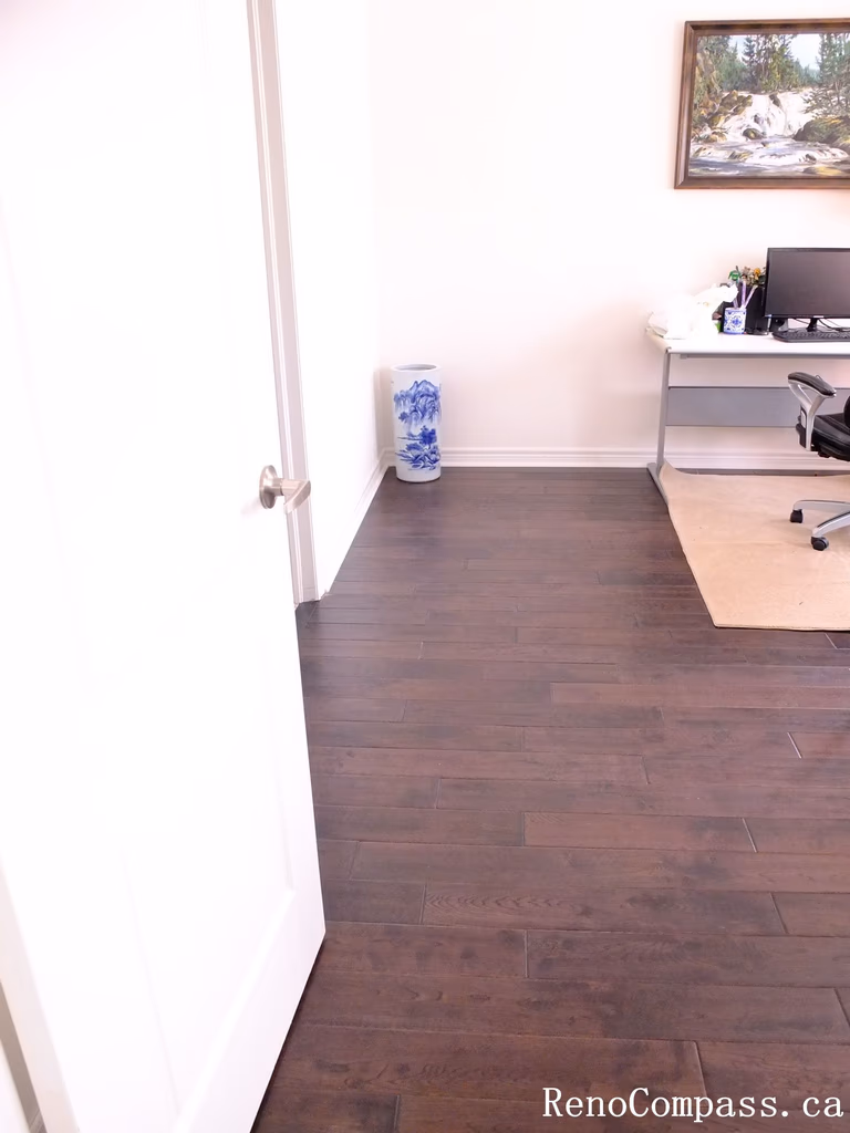 Toronto home hardwood flooring installation featuring deep-toned wood floors throughout the hallway and upper level. This professional flooring renovation enhances brightness, durability, and visual continuity, completed by Reno Compass for a clean and modern interior upgrade.