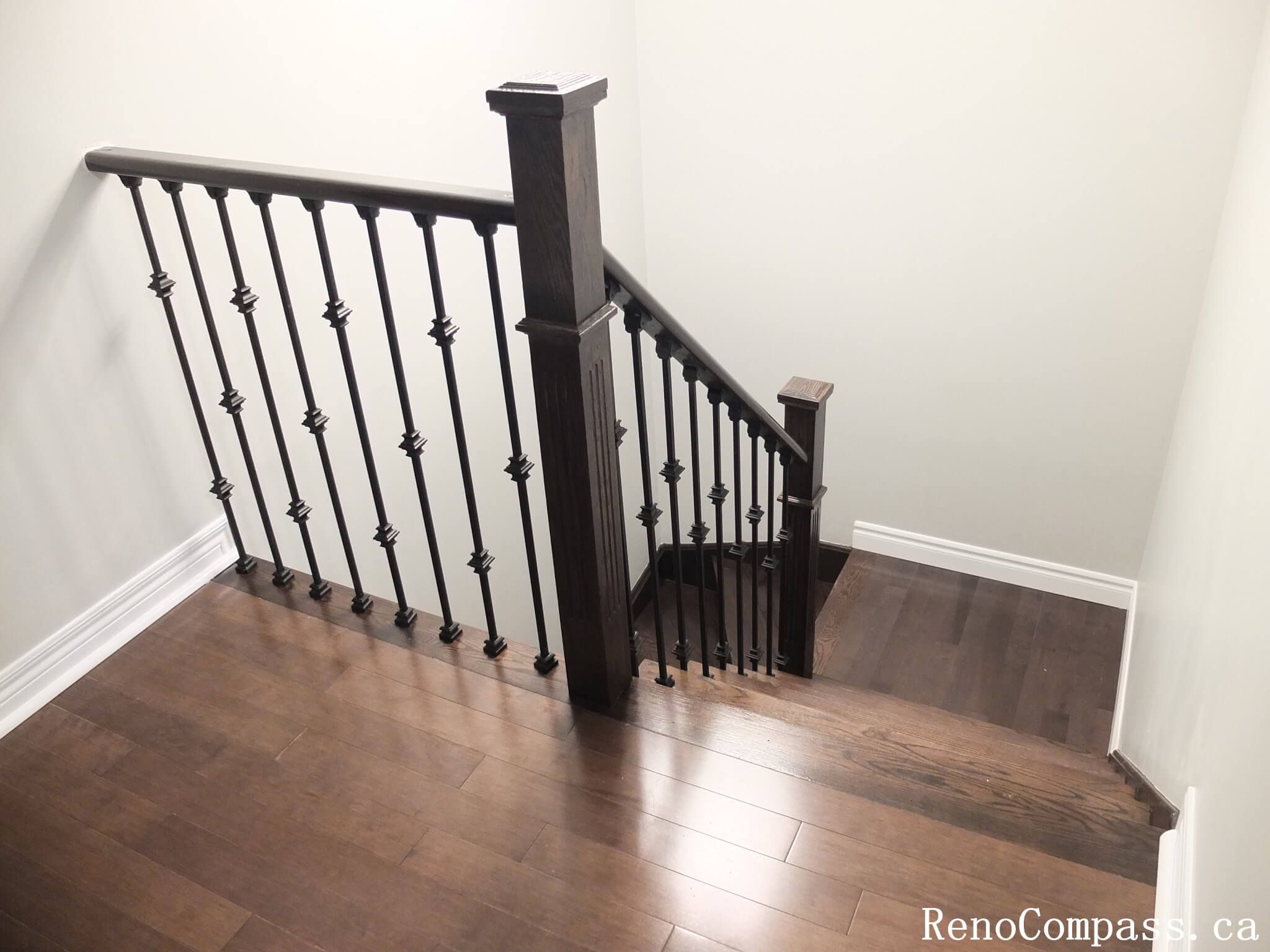 This Richmond Hill interior renovation showcases a modern staircase upgrade featuring dark hardwood flooring paired with custom black iron railings and solid wood posts. Completed by an experienced Toronto renovation company, the design enhances safety, durability, and visual elegance while creating a cohesive connection between floors. The refined railing details and warm wood tones add a sophisticated architectural element to the home’s interior.