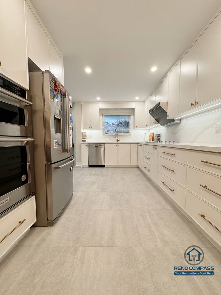 This Mississauga kitchen renovation features a refined galley-style layout with full-height custom cabinetry, integrated appliances, and streamlined storage. Light-toned finishes, quartz countertops, and recessed lighting enhance brightness while maintaining a clean, functional flow designed for everyday use.