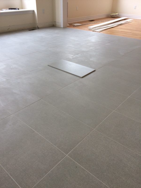 Large-format tile flooring installation in a Toronto interior renovation project. Clean tile alignment, consistent grout lines, and precise layout preparation help create a modern, durable, and easy-maintenance living space for everyday use.