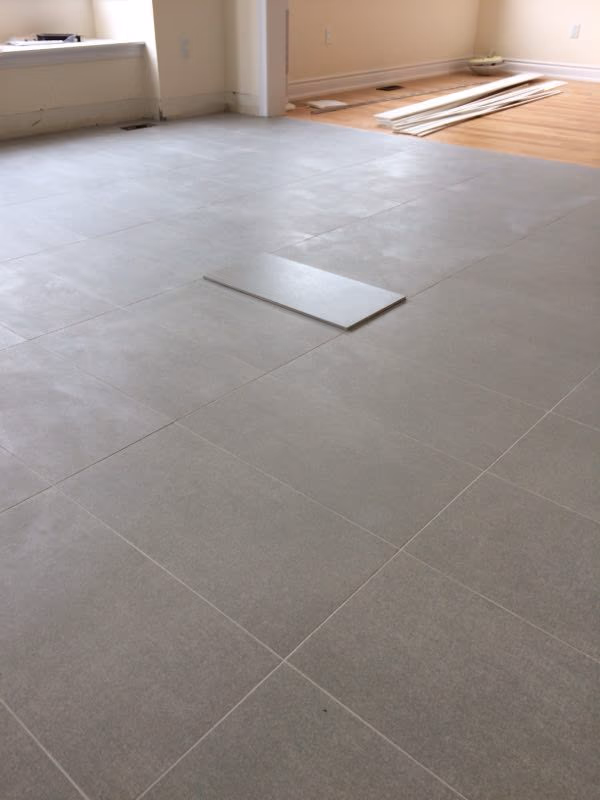 Large-format tile flooring installation in a Toronto interior renovation project. Clean tile alignment, consistent grout lines, and precise layout preparation help create a modern, durable, and easy-maintenance living space for everyday use.