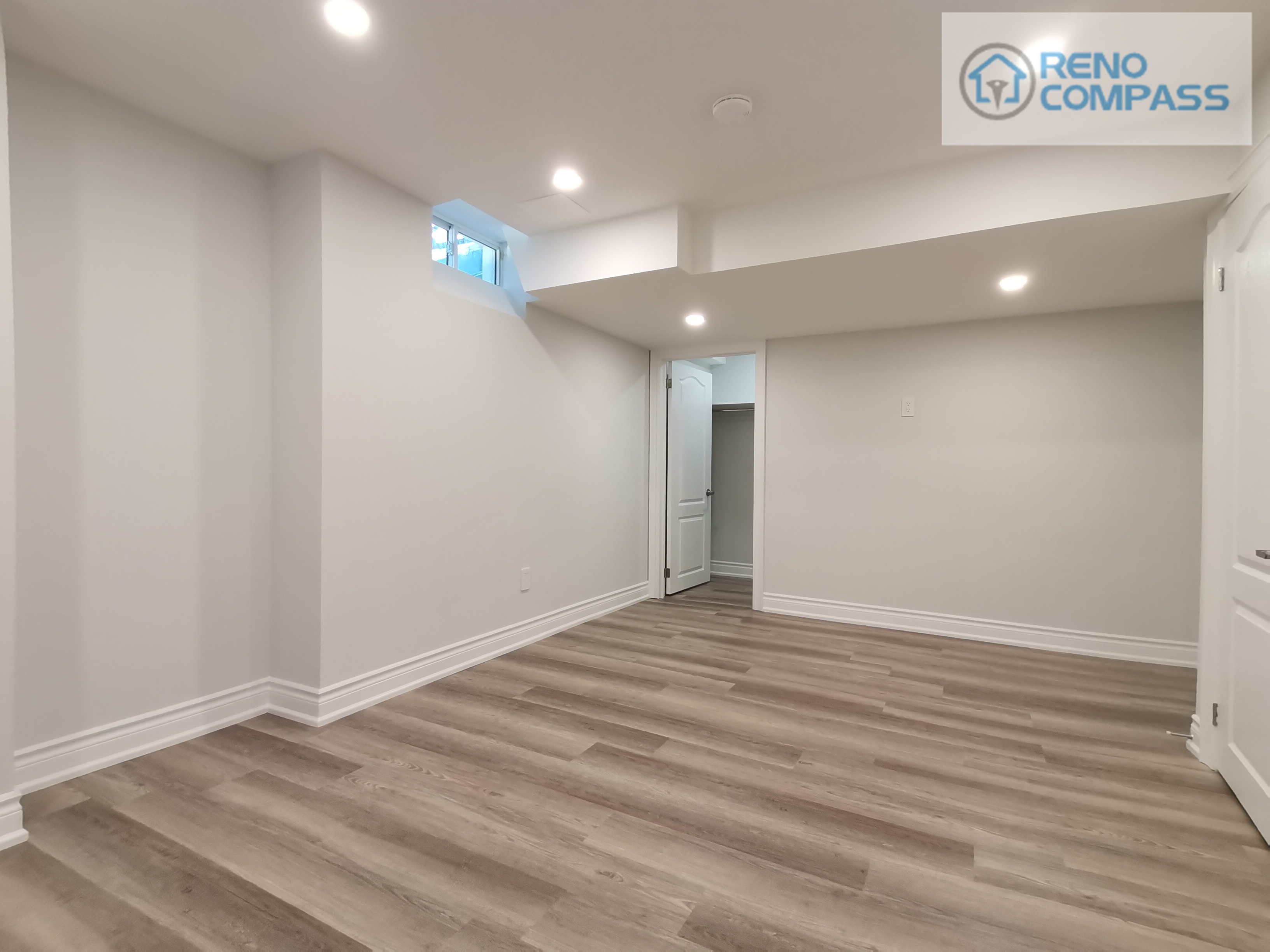 This Woodbridge basement renovation features a bright and open living area finished with durable vinyl flooring and recessed ceiling lights. Clean wall lines and optimized ceiling bulkhead design help maximize usable space, making the area suitable for a family room, home office, or entertainment zone. The neutral color palette ensures flexibility for long-term use and future layout adjustments.