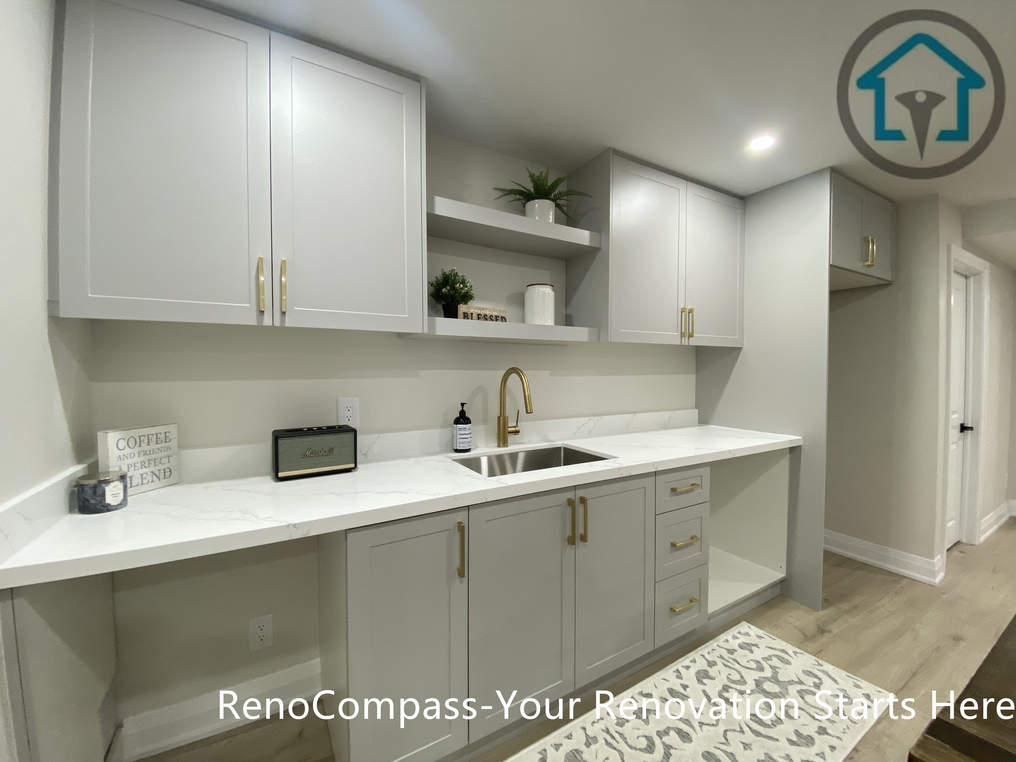 该画面展示了本次旺市地下室翻新项目中的定制橱柜与洗手台区域。Reno Compass 团队根据地下室的实际使用需求，规划并安装整套定制橱柜系统，结合石英台面与嵌入式洗手台，为地下空间提供实用的清洁、备餐与辅助功能。浅色柜体搭配金属拉手与简洁线条，在提升储物能力的同时，保持空间整洁有序，使地下室在功能性与整体风格上与住宅其他区域保持一致。