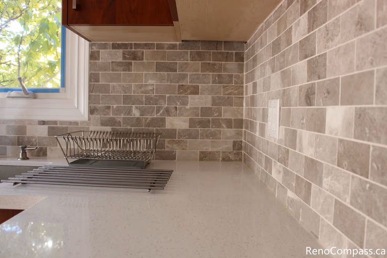 This detailed kitchen view highlights the quartz countertop and neutral mosaic tile backsplash installed during a full house renovation in Mississauga. The upgraded materials provide durability, easy maintenance, and a clean modern aesthetic that complements the custom cabinetry. Completed by a professional Toronto renovation company, this kitchen renovation enhances both visual appeal and everyday functionality while creating a bright and timeless cooking space.