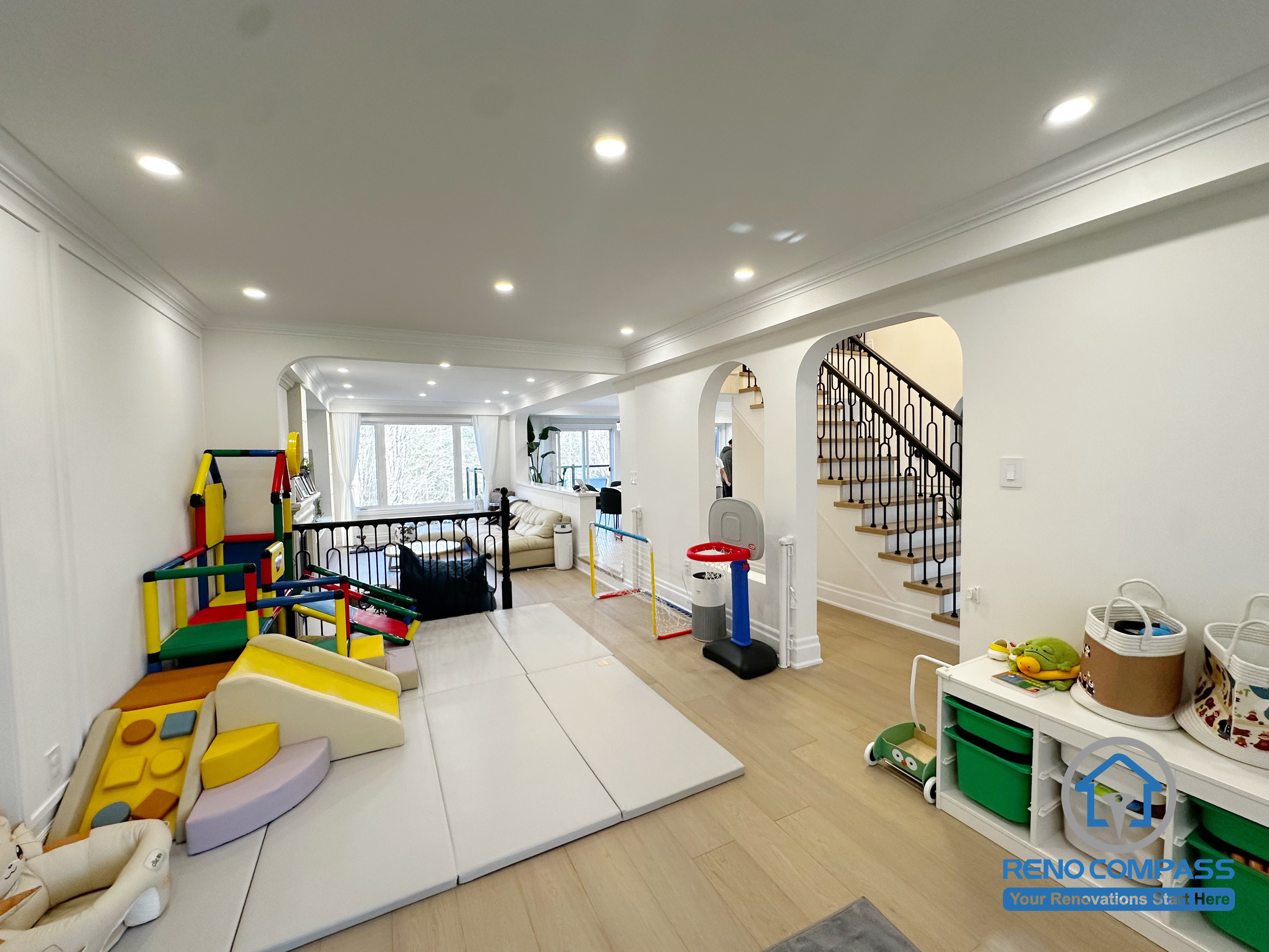 This Markham interior renovation was designed with everyday family life in mind, transforming the main living area into a flexible, child-friendly space that supports both play and relaxation. The open layout allows parents to maintain clear sightlines across the room while creating a safe and comfortable area for children’s activities.

Arched openings and consistent ceiling details help connect different zones of the home, while layered recessed lighting ensures the space remains bright and functional throughout the day. The combination of soft play areas and durable flooring makes the room adaptable as family needs evolve over time.

By balancing openness, safety, and long-term usability, this interior renovation creates a welcoming environment that works seamlessly for modern family living in Markham.
