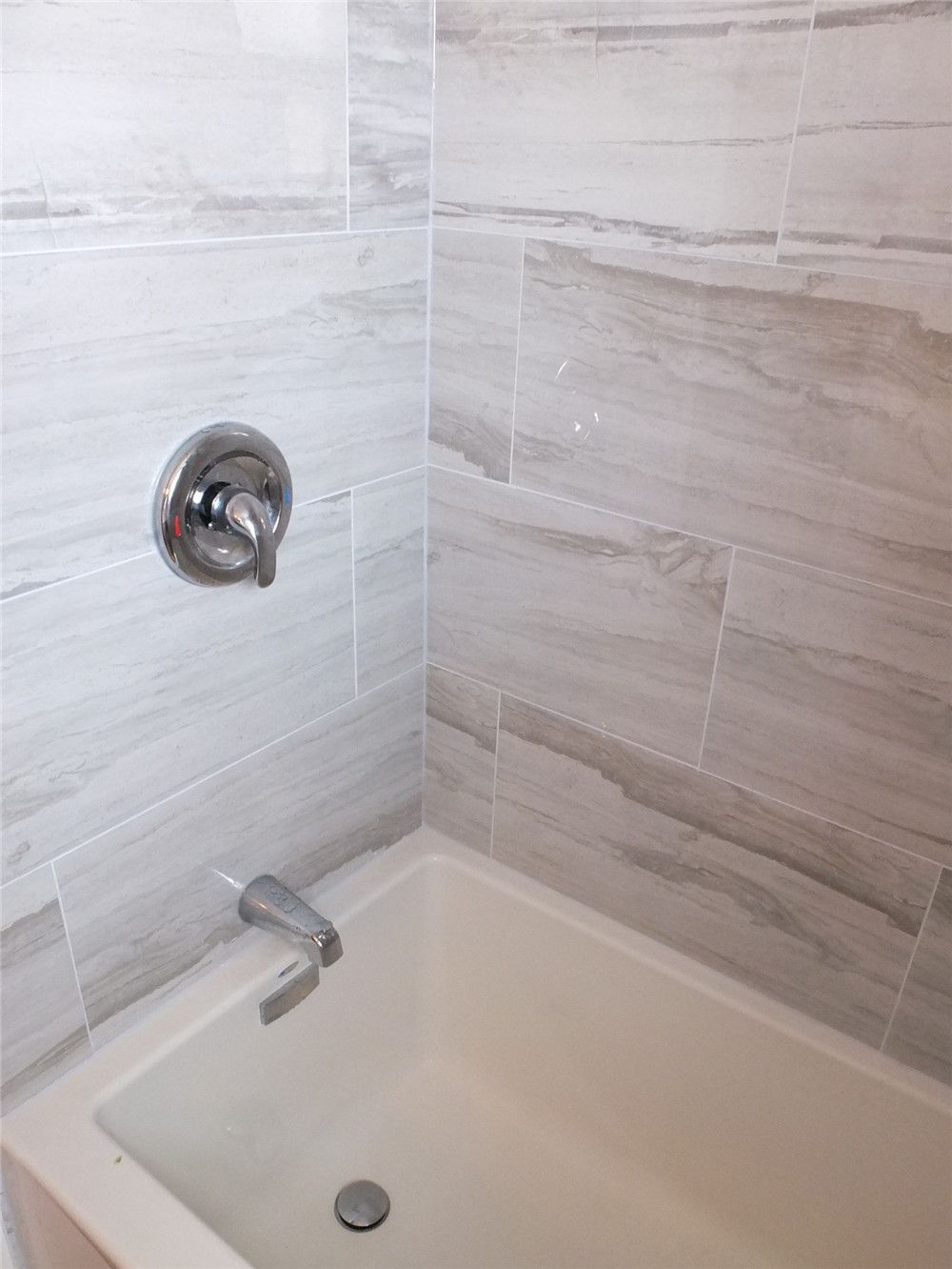 This North York bathroom renovation includes a new bathtub installation with modern wood-look porcelain wall tiles for a clean and contemporary appearance. The updated shower valve, durable tile finish, and moisture-resistant materials improve both functionality and long-term maintenance. Completed by a professional Toronto renovation company, the design provides a bright, practical bathing space suitable for everyday comfort.