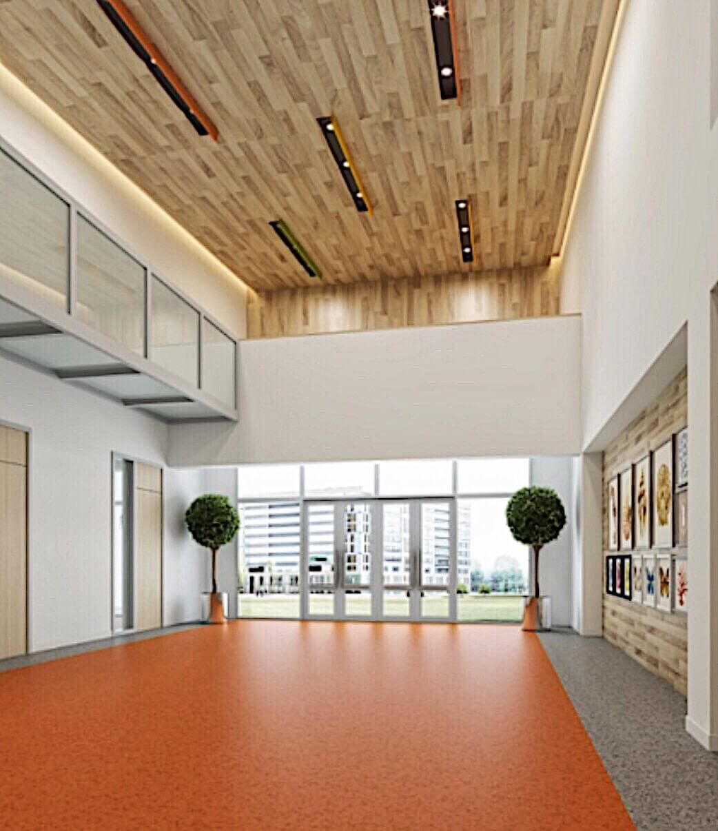 This Toronto daycare renovation showcases a bright and welcoming lobby and multipurpose activity area designed for young learners and families. The space features a high wood-finish ceiling with modern linear lighting, vibrant orange safety flooring, and large glass doors that allow natural light to fill the interior.

The open layout creates a flexible environment for drop-off, events, and indoor activities while maintaining a clean and contemporary aesthetic. This commercial daycare interior renovation in Toronto highlights functional design, child-friendly materials, and a warm atmosphere that enhances both safety and daily operations.