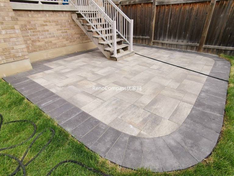 A stunning backyard interlocking patio in Vaughan featuring a defined dark border and seamless transition to the lawn area. Designed and installed by Reno Compass, this elegant stone layout provides a durable and stylish space for outdoor living.