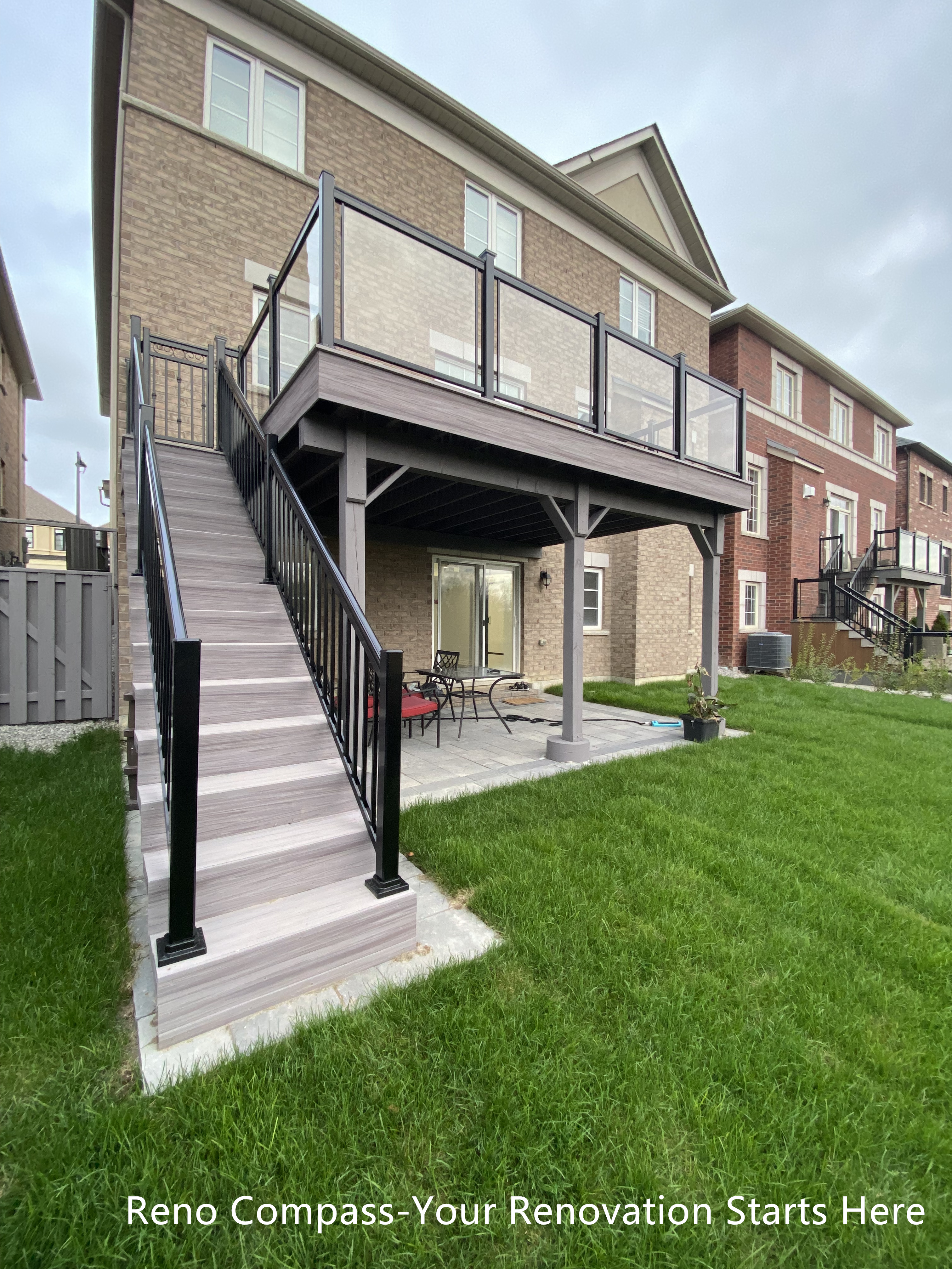 Stunning Aurora deck renovation with elevated wooden deck, black metal railings, and a spacious patio below. Perfect for entertaining, outdoor dining, and enjoying scenic backyard views. Project by Reno Compass Inc.