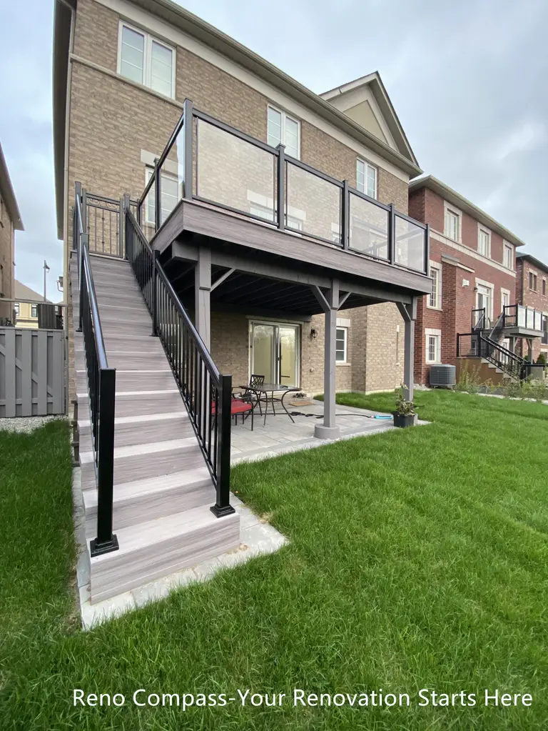 Stunning Aurora deck renovation with elevated wooden deck, black metal railings, and a spacious patio below. Perfect for entertaining, outdoor dining, and enjoying scenic backyard views. Project by Reno Compass Inc.