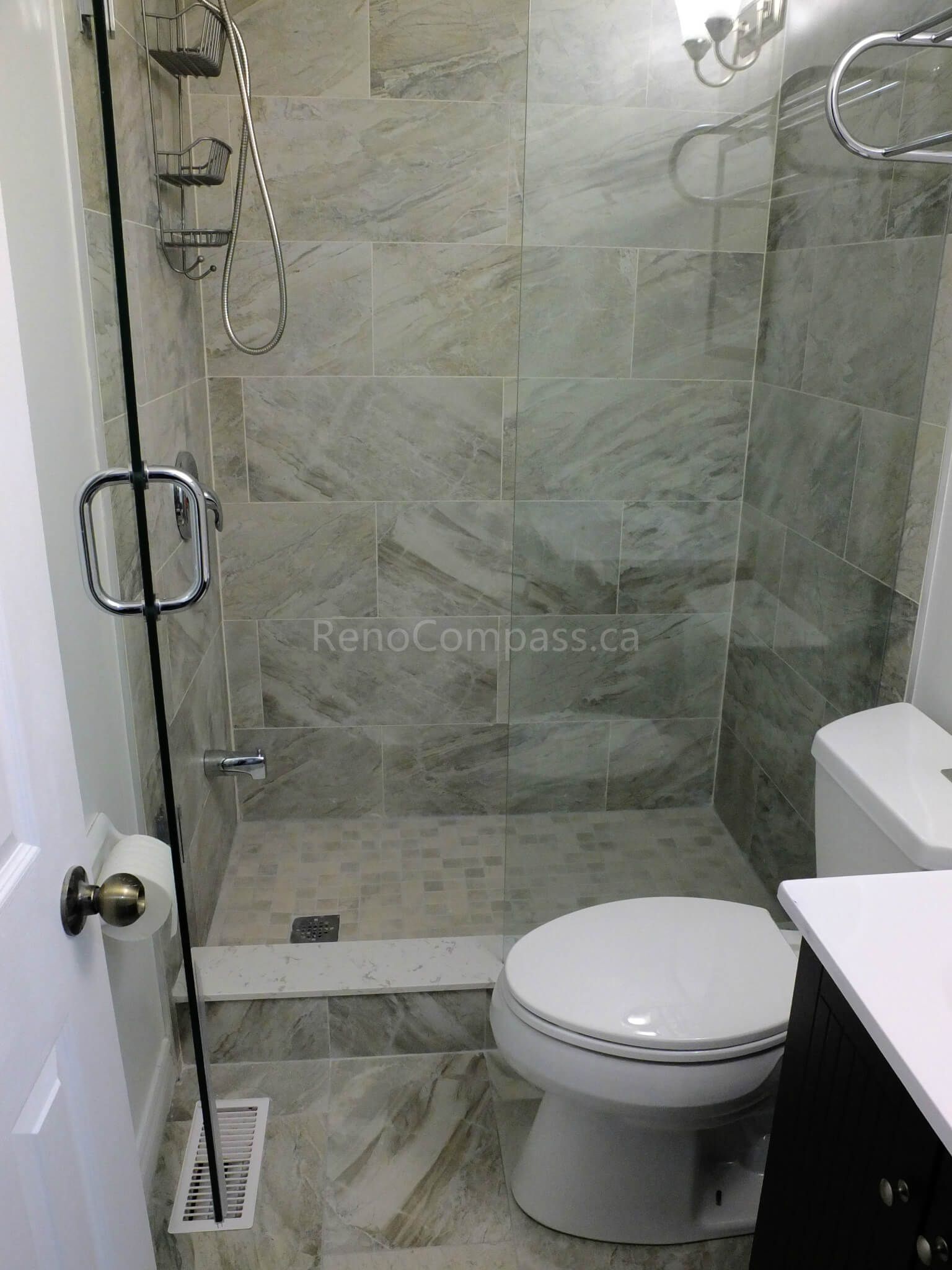 This North York bathroom renovation showcases a modern walk-in glass shower with full-height marble-look tile walls, upgraded fixtures, and a clean space-saving layout. Completed by a professional Toronto renovation company, the project focuses on maximizing functionality, improving lighting, and creating a bright, elegant bathroom with durable materials and precise finishing details.
