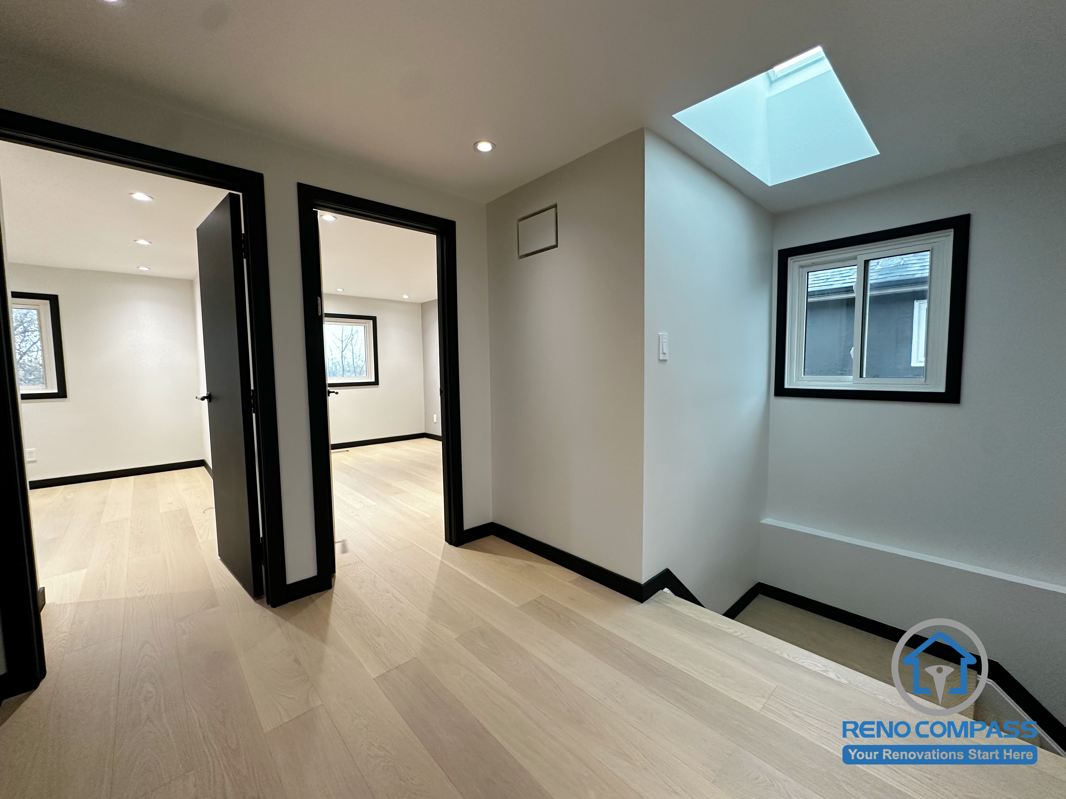A bright upstairs landing enhanced by a modern skylight, black-trimmed windows, and light oak flooring. The clean transitions between rooms create an open and spacious flow throughout the upper level.  二楼过道以天窗带来自然采光，搭配黑框窗与浅色木地板，让空间更显通透明亮。房间与走道的衔接简洁利落，打造开放又舒适的动线。