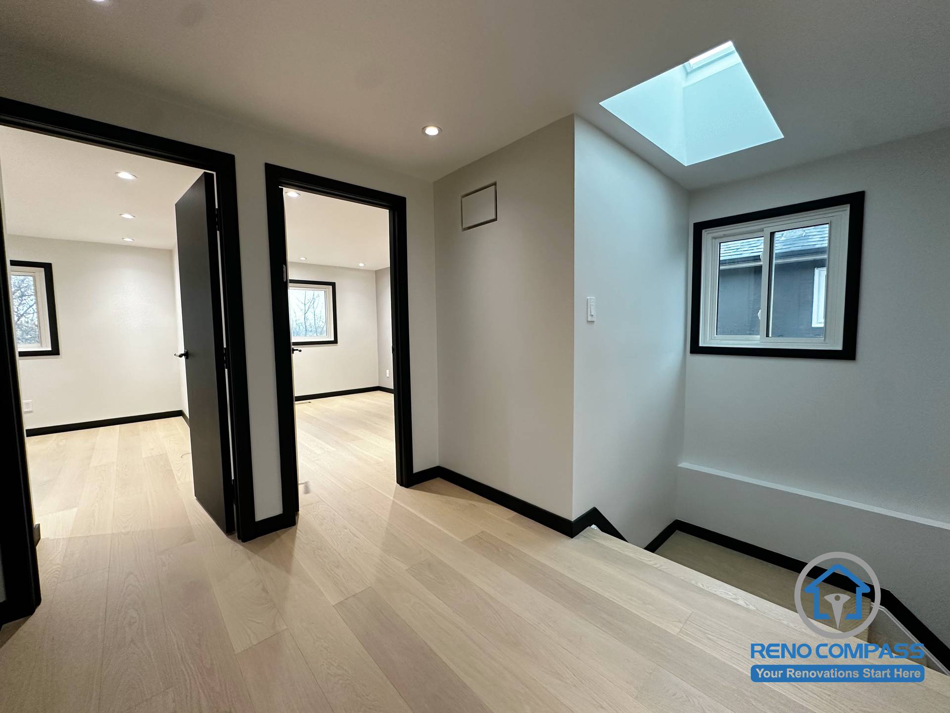 A bright upstairs landing enhanced by a modern skylight, black-trimmed windows, and light oak flooring. The clean transitions between rooms create an open and spacious flow throughout the upper level.  二楼过道以天窗带来自然采光，搭配黑框窗与浅色木地板，让空间更显通透明亮。房间与走道的衔接简洁利落，打造开放又舒适的动线。