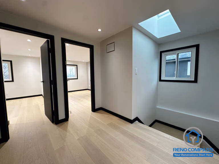 A bright upstairs landing enhanced by a modern skylight, black-trimmed windows, and light oak flooring. The clean transitions between rooms create an open and spacious flow throughout the upper level.  二楼过道以天窗带来自然采光，搭配黑框窗与浅色木地板，让空间更显通透明亮。房间与走道的衔接简洁利落，打造开放又舒适的动线。