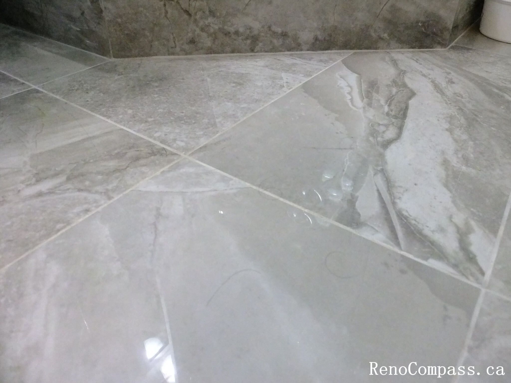 Bathroom renovation in North York showcasing large-format porcelain floor tiles with marble-look pattern and precise grout alignment. This Toronto interior renovation highlights durable flooring materials, clean tile layout, and careful installation for long-term performance in wet areas.