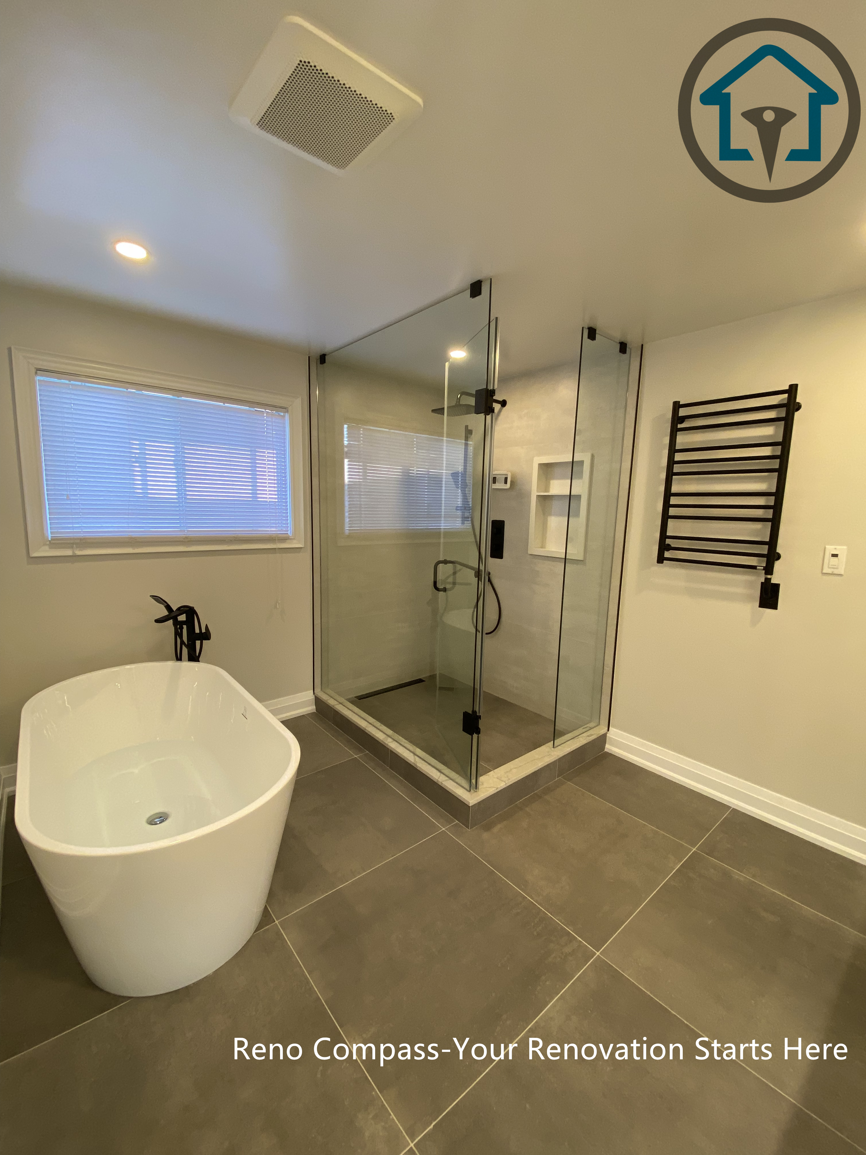 Spacious bathroom renovation in Markham featuring a frameless glass walk-in shower, freestanding soaking tub, large-format floor tiles, and modern matte black fixtures. The layout emphasizes comfort, functionality, and a clean contemporary aesthetic completed by a professional Toronto renovation company.