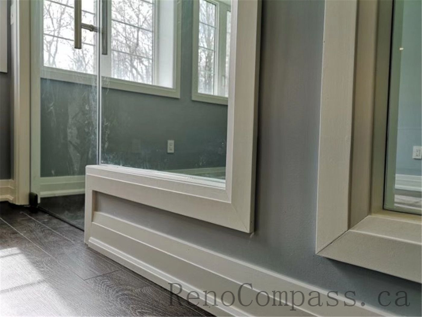 Contemporary basement renovation with a glass partition wall, maximizing natural light and creating an open, seamless flow between spaces. A refined Aurora project designed and built by Reno Compass.