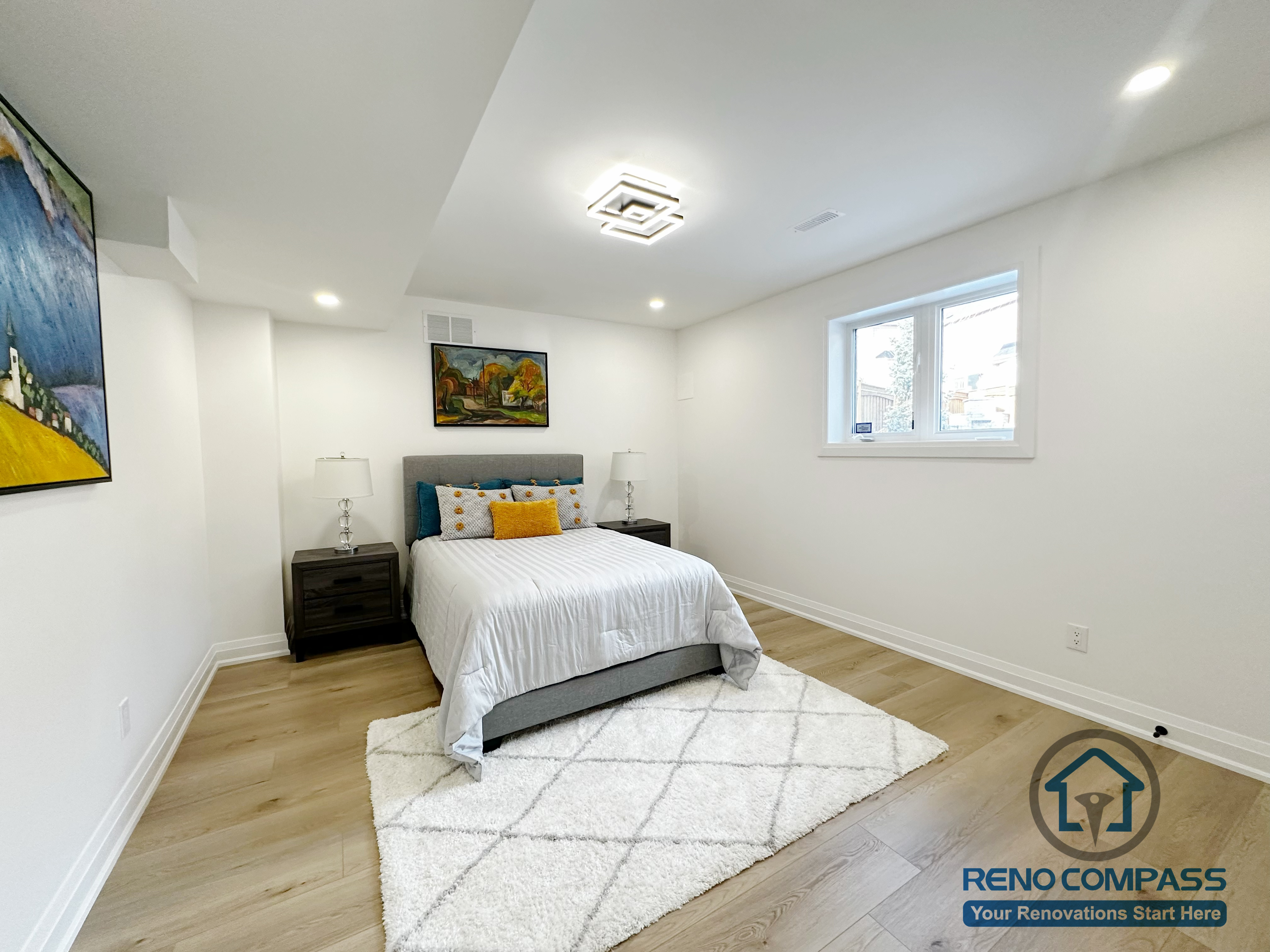 This Richmond Hill basement renovation includes a finished bedroom designed for comfort and everyday use. The space features an egress window that brings in natural light while meeting basement safety requirements. Neutral wall tones, recessed ceiling lighting, and wide-plank flooring help create a bright and balanced atmosphere. The layout comfortably accommodates a full-size bed and bedside furniture, making the room suitable for guests, extended family, or long-term basement living.