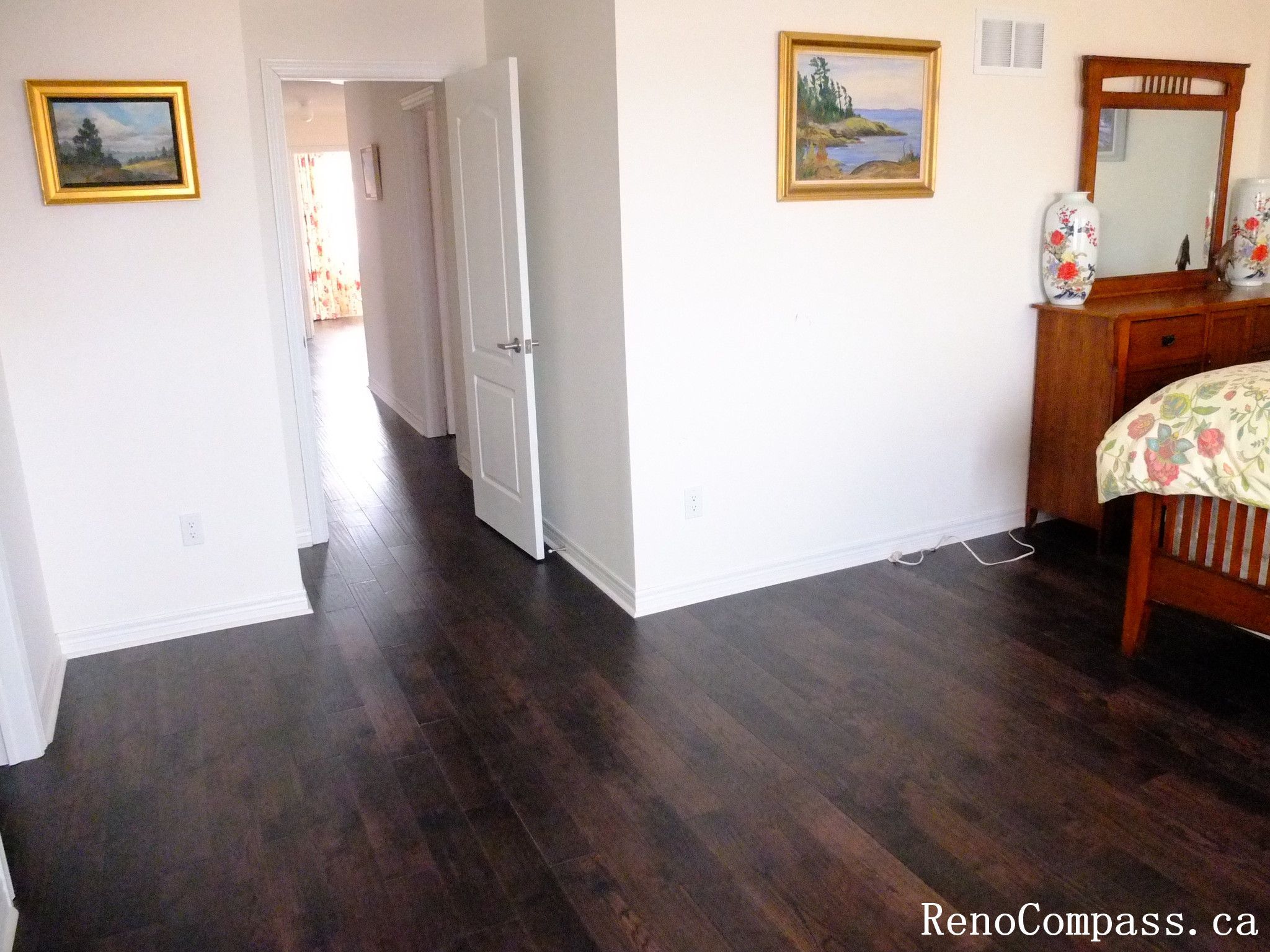 Toronto home hardwood flooring installation featuring deep-toned wood floors throughout the hallway and upper level. This professional flooring renovation enhances brightness, durability, and visual continuity, completed by Reno Compass for a clean and modern interior upgrade.
