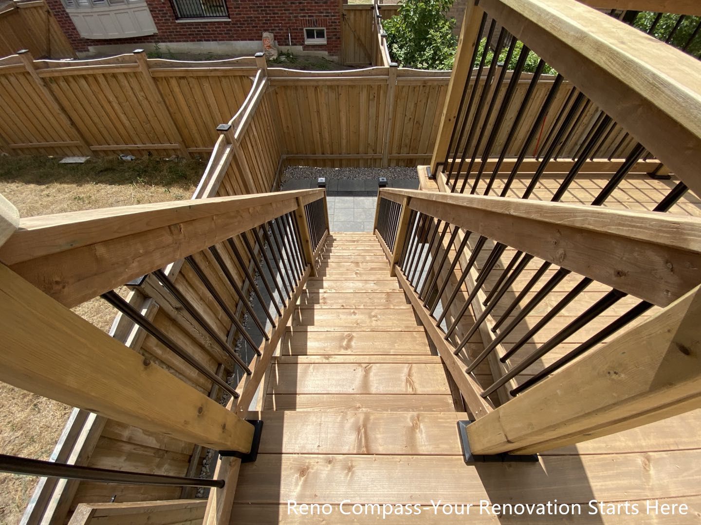 This Markham outdoor renovation highlights a custom-built wooden deck staircase connecting the raised deck to the interlocking patio below. Pressure-treated wood steps provide a sturdy, slip-resistant surface, while black metal railings ensure safety and visual continuity with the deck above. The staircase creates a smooth, practical transition between outdoor levels, improving circulation and accessibility throughout the backyard. Precise construction and balanced proportions support long-term durability and everyday use. This deck and patio renovation was completed by Reno Compass, serving homeowners in Markham and across the GTA.