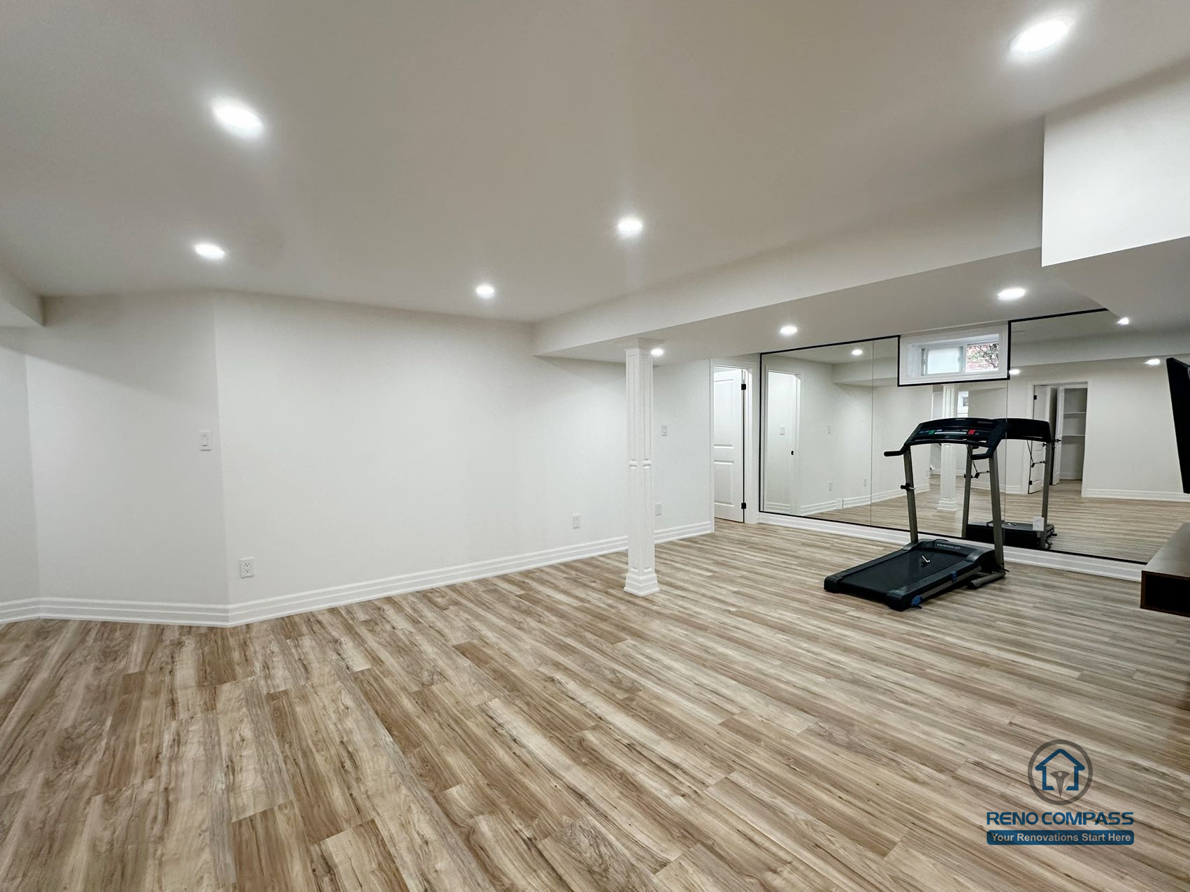 This image showcases a completed basement renovation in Pickering, featuring an open-concept layout designed for flexible everyday use. The space combines a functional kitchenette, open living area, and exercise zone, supported by consistent flooring and recessed lighting throughout. Structural columns are carefully integrated into the layout to maintain openness while preserving necessary support. Neutral finishes and clean ceiling lines enhance brightness and visual continuity, allowing the basement to function comfortably as an extension of the main living area.
Location: Pickering · Toronto Contractor: Reno Compass