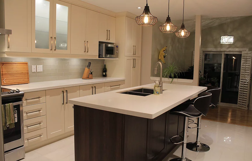 This Mississauga kitchen renovation features custom cream cabinetry, a large quartz island, modern pendant lighting, and upgraded backsplash design. Completed by a professional Toronto renovation company, the project focuses on improving functionality, storage, and modern aesthetics. The spacious island with built-in sink and seating enhances daily use and entertaining, while new lighting and finishes create a warm, elegant atmosphere. Ideal for homeowners in Mississauga seeking a stylish and practical kitchen upgrade with high-quality craftsmanship and thoughtful layout planning.