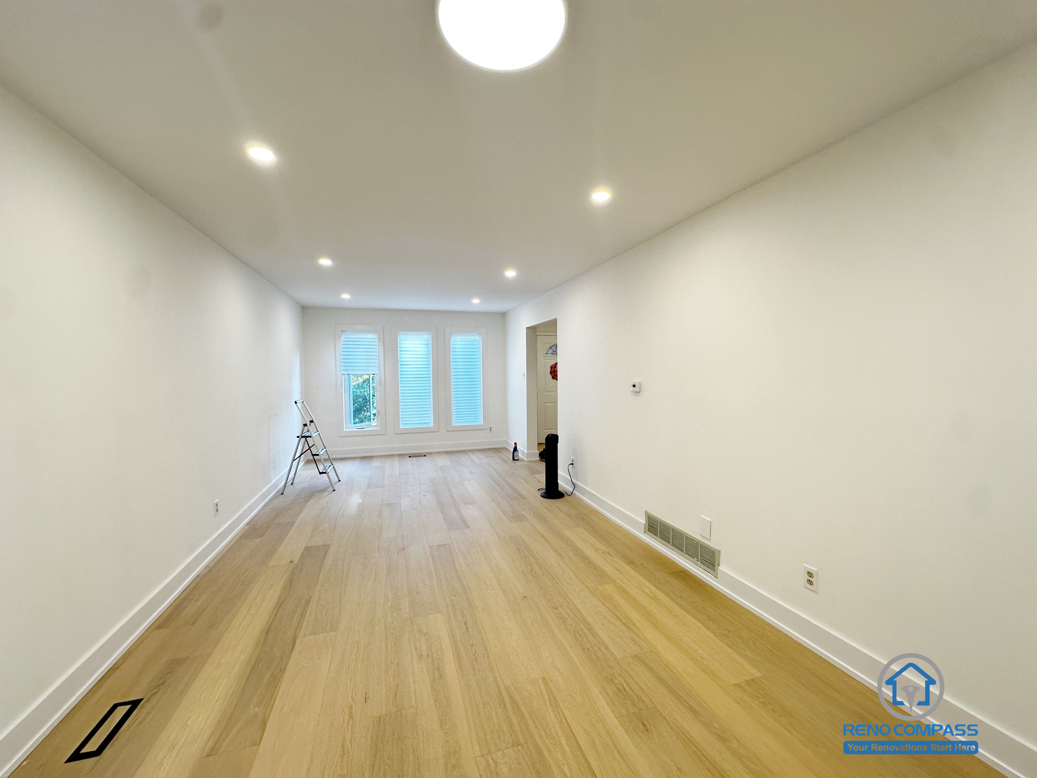 This Richmond Hill interior renovation features a long, open living area with natural hardwood flooring and recessed ceiling lighting that enhances depth and brightness. The clean wall lines and balanced lighting layout create a flexible space suitable for living, dining, or multi-purpose use. Large rear windows bring in natural light, reinforcing a comfortable and functional atmosphere. Completed as part of a Toronto renovation project focused on spatial flow, durability, and everyday livability.