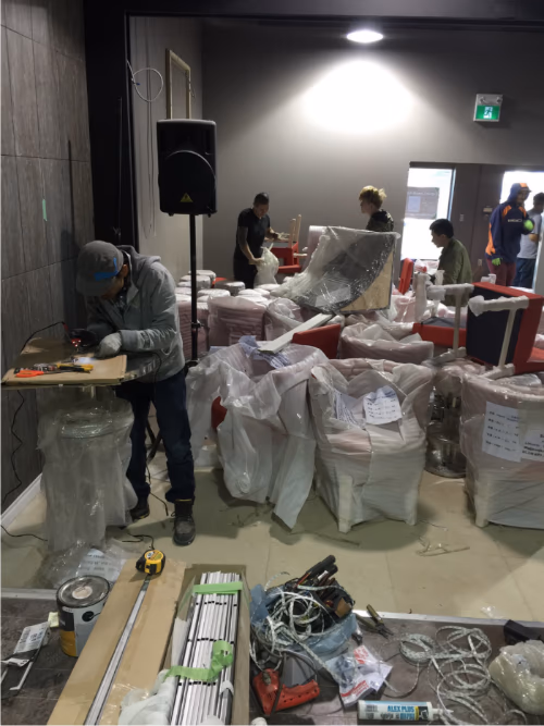 This image captures the equipment delivery phase of a 7000 sqft private club renovation project in Toronto. Large commercial fixtures and custom-built components are being unloaded from a shipping container, carefully prepared for interior installation.

The project involves coordinated logistics, material handling, and staged installation to ensure smooth construction progress. Deliveries like these typically include custom furniture, structural components, or entertainment-related equipment required for a high-end private club build-out.

Managed by an experienced Toronto renovation team, this large-scale commercial project demonstrates organized project planning, safe material handling, and professional construction workflow from delivery to final installation.