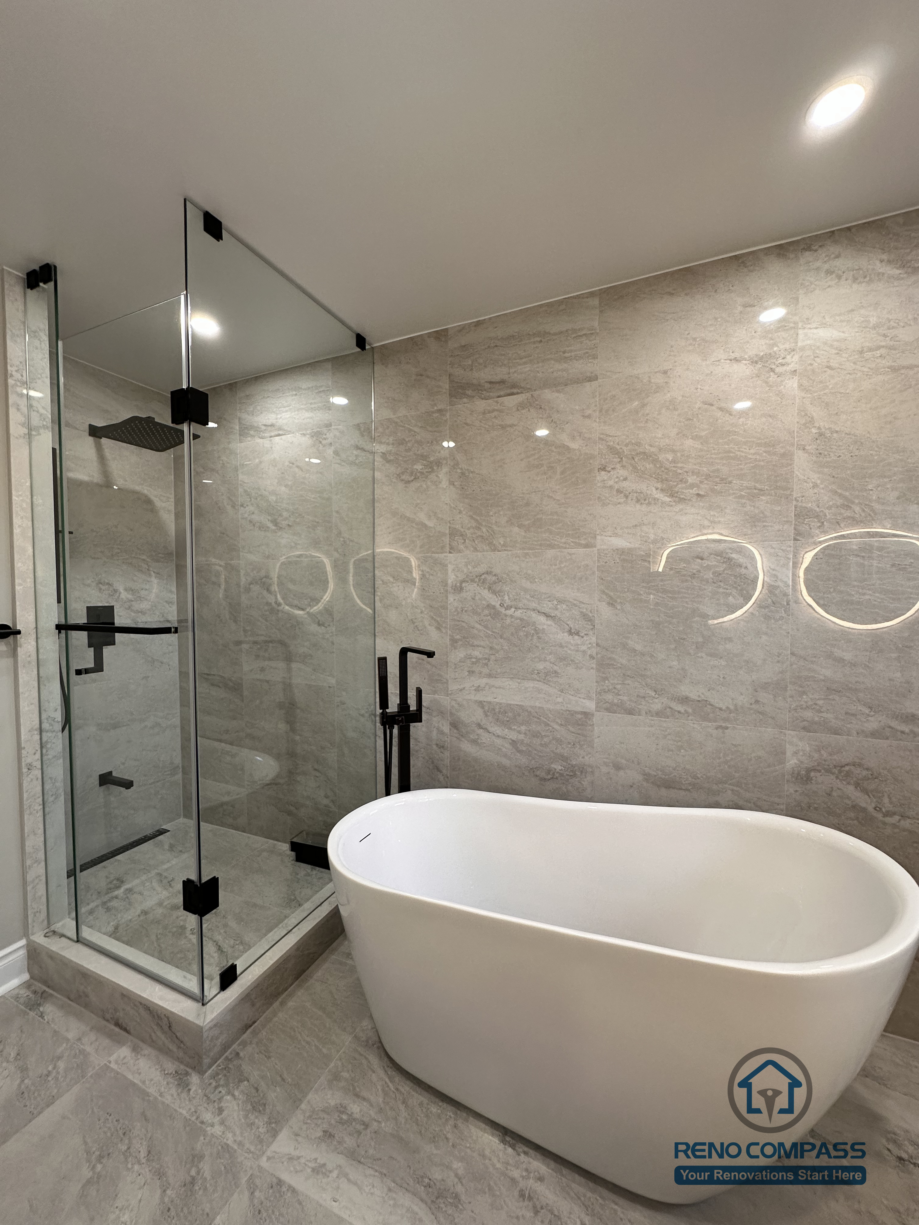 This Markham bathroom renovation features a modern layout with a freestanding bathtub, glass-enclosed shower, and large-format stone-look tiles. Designed and built by a professional Toronto renovation company, Reno Compass Inc., the space balances functionality, clean lines, and long-term durability.