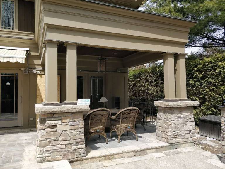 Oakville backyard covered patio featuring stone columns, architectural pillars, and a spacious seating area. Designed for comfort, shade, and elegant outdoor living.