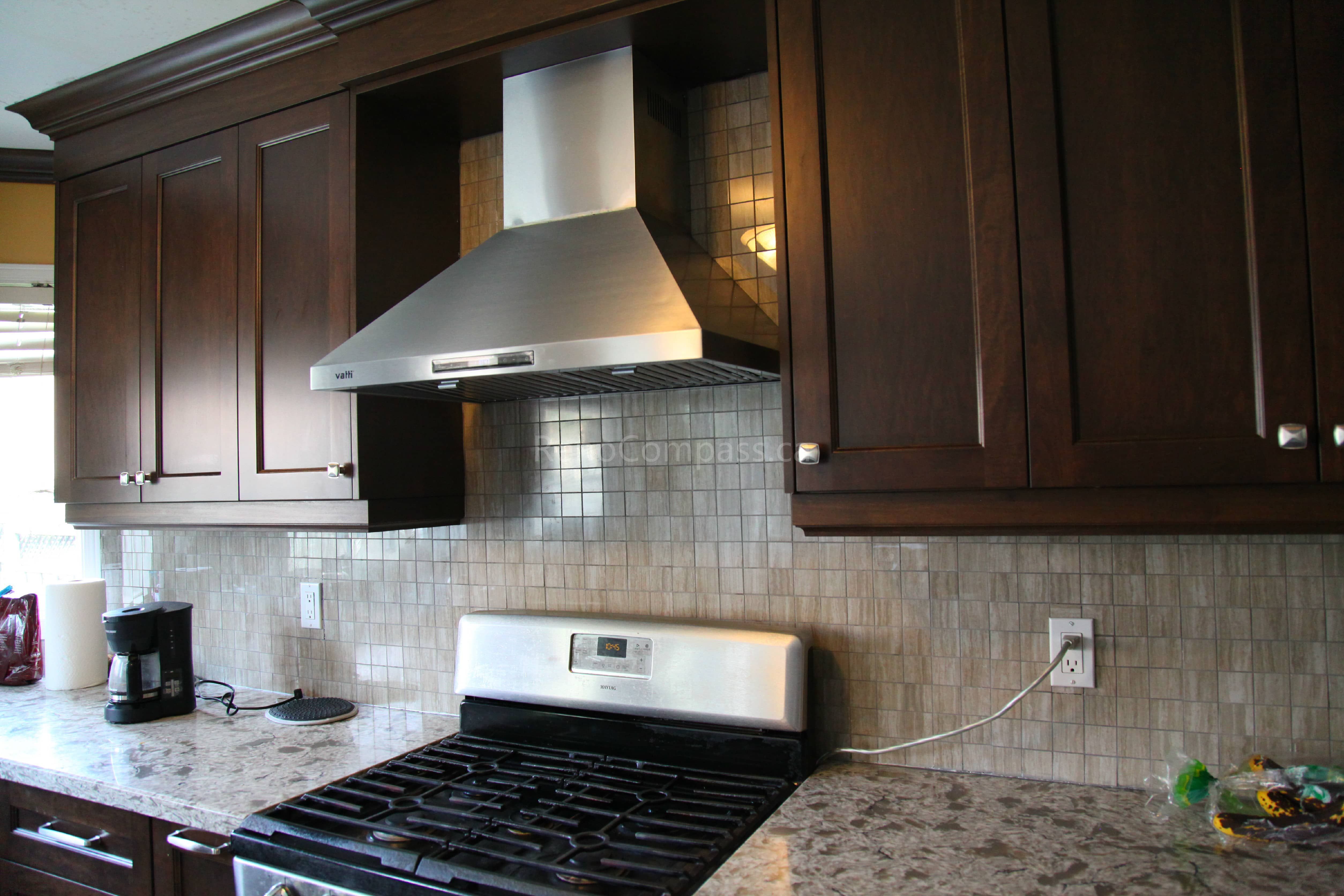 This Markham kitchen renovation highlights a custom stainless steel range hood, mosaic tile backsplash, and upgraded granite countertops paired with rich wood cabinetry. Completed by a trusted Toronto renovation company, the project enhances both ventilation efficiency and visual sophistication, creating a modern and highly functional cooking environment with timeless appeal.