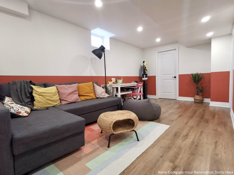 This image features a renovated basement family room in Vaughan, designed as a flexible living space suitable for relaxation, play, and everyday family activities. The layout combines comfortable seating, soft lighting, and durable wood flooring to create a welcoming and practical environment. Recessed ceiling lights and a small window provide balanced illumination, while the open arrangement allows the space to adapt to different uses such as lounging, children’s activities, or casual gatherings. This basement renovation demonstrates the thoughtful space planning and construction quality delivered by a professional Toronto renovation company focused on functional residential interiors.