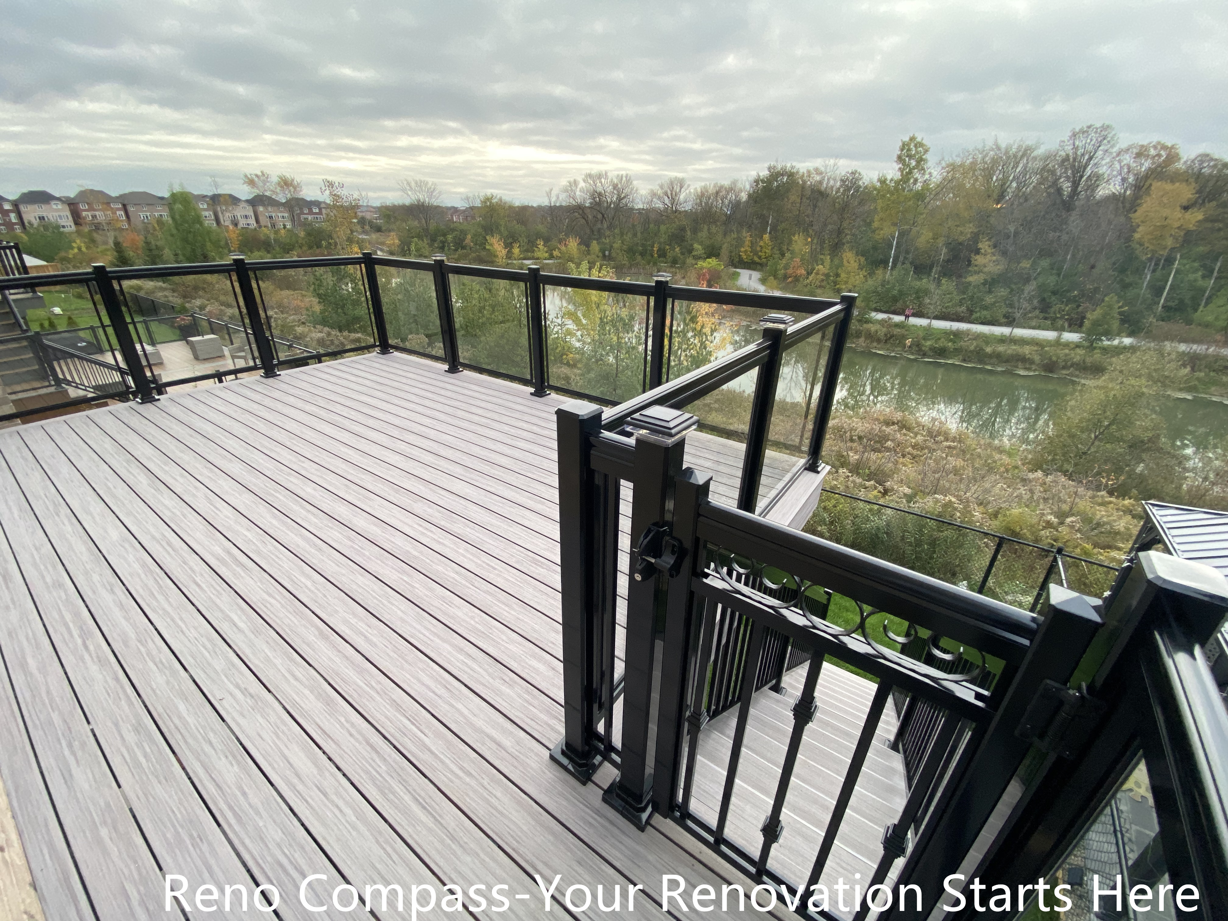 Modern Aurora deck featuring durable wooden flooring and sleek glass railings, designed for outdoor leisure, family gatherings, and seamless integration with the home exterior. Project by Reno Compass Inc.