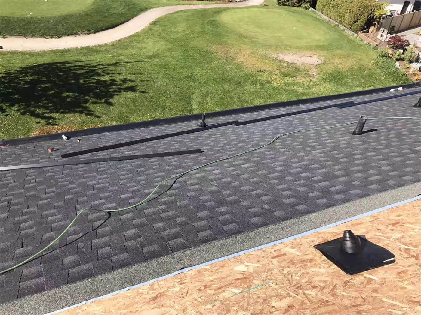 New asphalt shingle roof installation in Toronto, showing precise shingle alignment, proper underlayment coverage, and clean roof edge detailing. The roofing system includes upgraded flashing and vent pipe installation to ensure effective water drainage, ventilation, and long-term weather resistance. This roof replacement improves both durability and curb appeal while meeting Toronto building code standards.