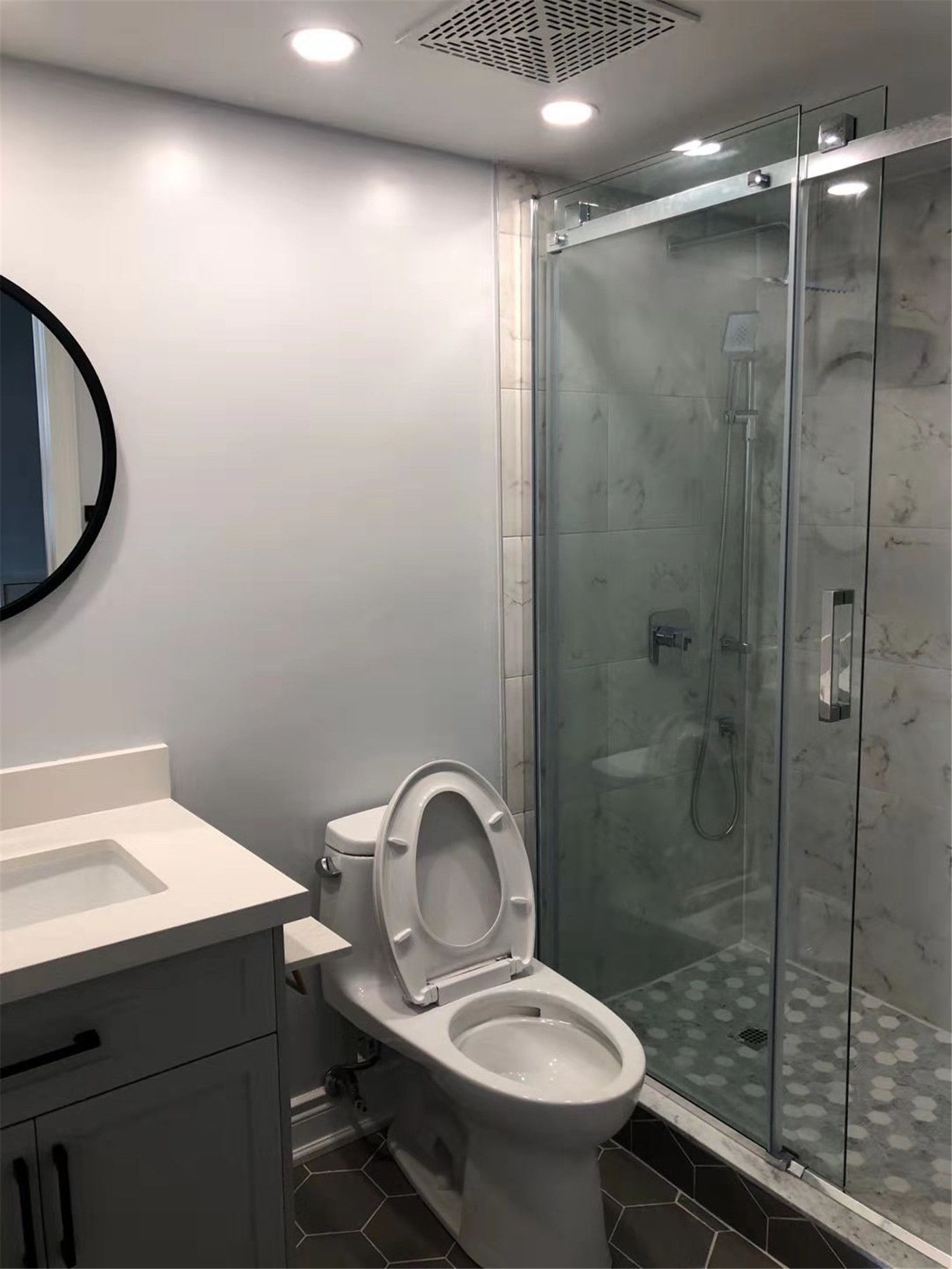 Condo bathroom renovation in Richmond Hill featuring a modern vanity with quartz countertop, a sleek toilet installation, and a frameless glass shower enclosure. The bathroom upgrade includes elegant tile flooring and a stylish shower design that enhances both comfort and functionality, creating a clean and contemporary space suitable for modern condo living.