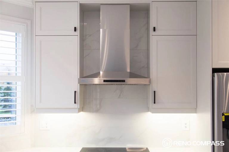 This Markham kitchen renovation highlights custom white shaker cabinets paired with a sleek stainless steel range hood and marble-look backsplash. The clean lines, modern finishes, and built-in cabinetry create a bright, functional, and elegant cooking space designed for both style and everyday use.