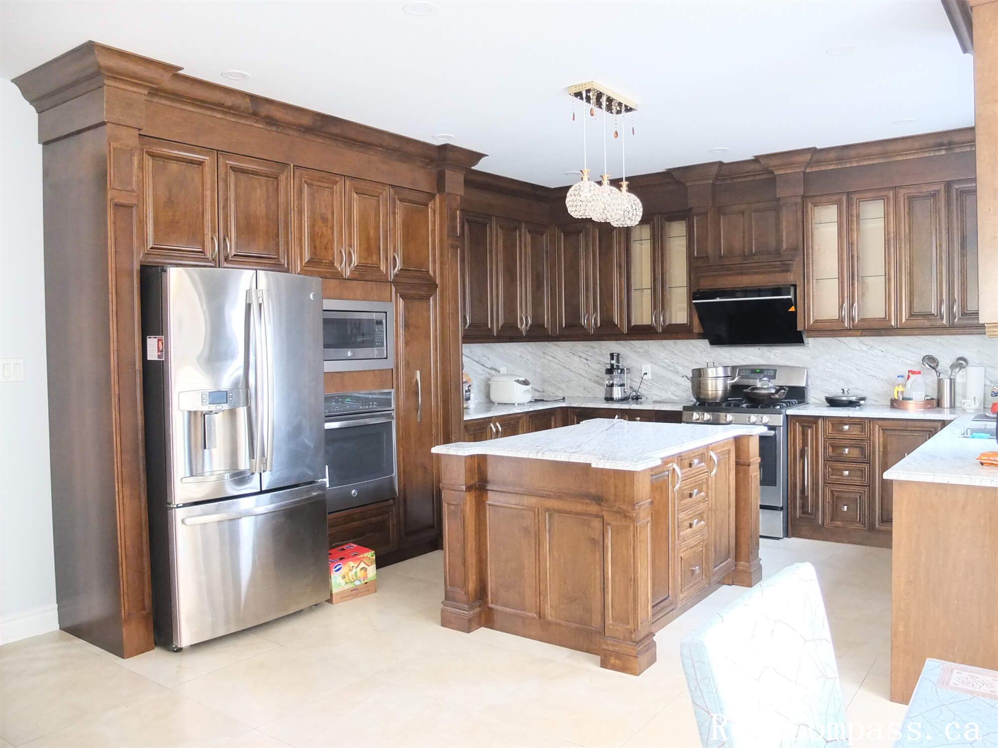 This Richmond Hill interior renovation features a spacious upgraded kitchen with custom solid wood cabinetry, a central island, quartz countertops, and stainless steel appliances. The layout is designed to improve workflow and storage while maintaining a warm and elegant aesthetic. Detailed millwork, modern lighting fixtures, and durable flooring create a functional yet timeless kitchen space for everyday family living. Completed by a professional Toronto renovation company, this kitchen renovation enhances both property value and long-term usability.