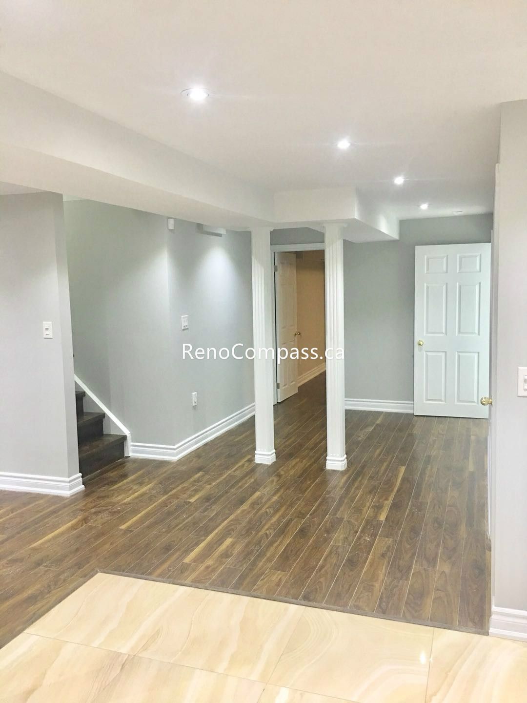 This Toronto basement renovation showcases a newly finished open-concept space with modern vinyl flooring, fresh neutral wall paint, and recessed LED lighting. The upgraded support column, clean trim work, and durable flooring create a bright and functional living area perfect for entertainment or rental use. Completed by Reno Compass Inc., this basement transformation enhances comfort, property value, and everyday usability for Toronto homeowners.