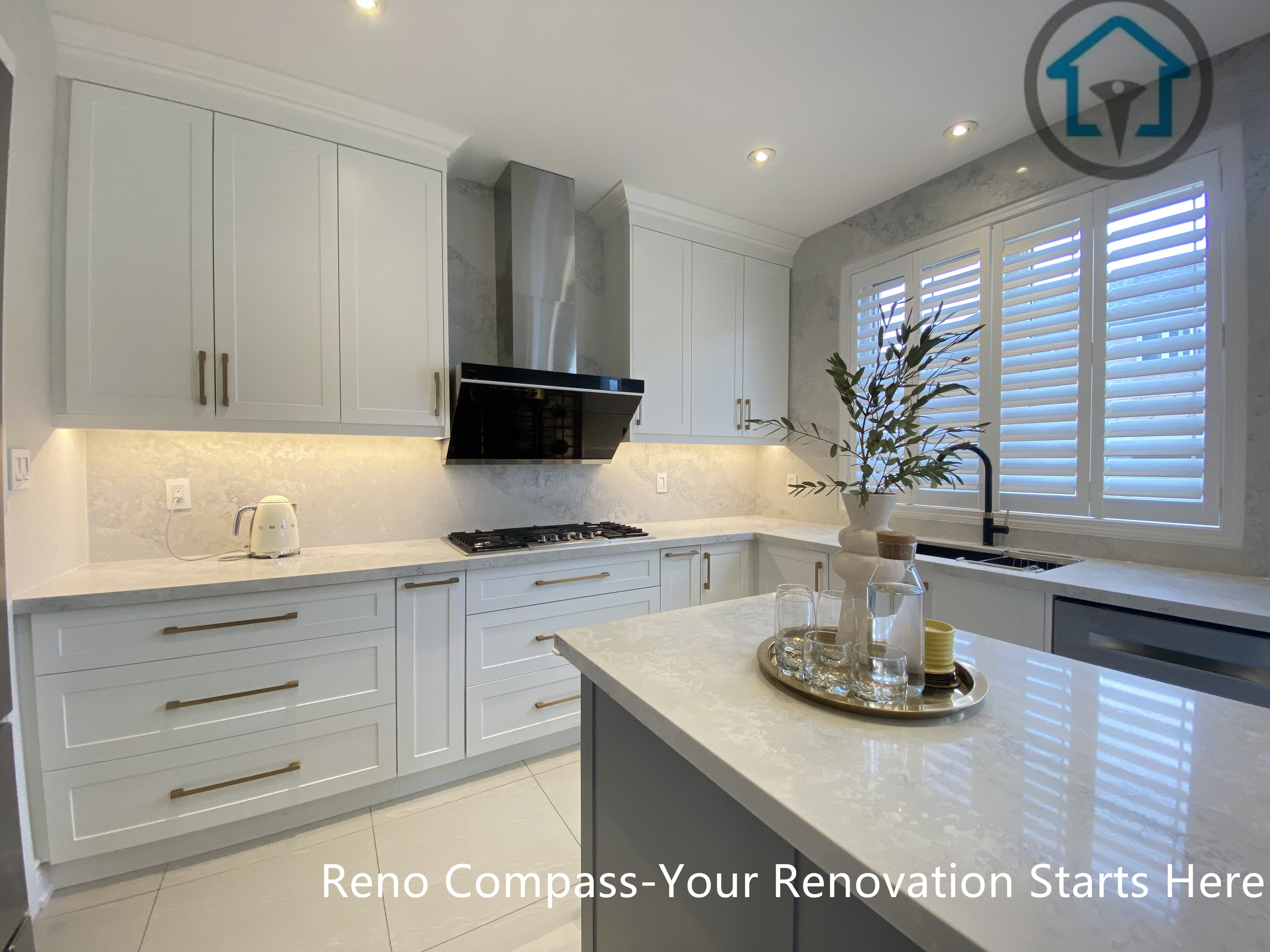 This image showcases the relationship between the central kitchen island and the main working zone in this Markham kitchen renovation. The layout combines custom white cabinetry, a gas cooktop wall, and a spacious island designed for prep, gathering, and daily use. Natural light from the window and integrated lighting enhance the sense of openness and balance. Designed and built by Reno Compass, this kitchen reflects a practical yet refined approach to modern kitchen renovation in Markham.