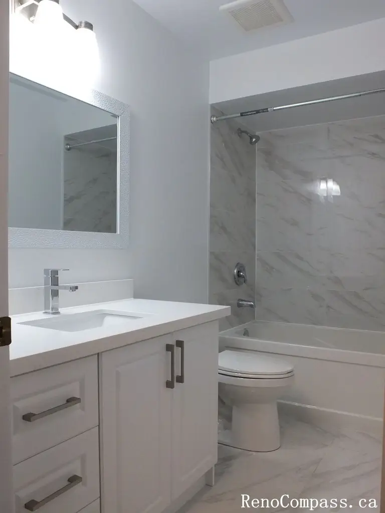 This Richmond Hill bathroom renovation features a clean tub-shower combination with marble-look wall tiles, modern glass doors, and a sleek vanity. Completed by a professional Toronto renovation company, the layout maximizes functionality while maintaining a bright and contemporary aesthetic. Neutral finishes and durable materials create a fresh, low-maintenance bathroom designed for everyday comfort and long-term use.