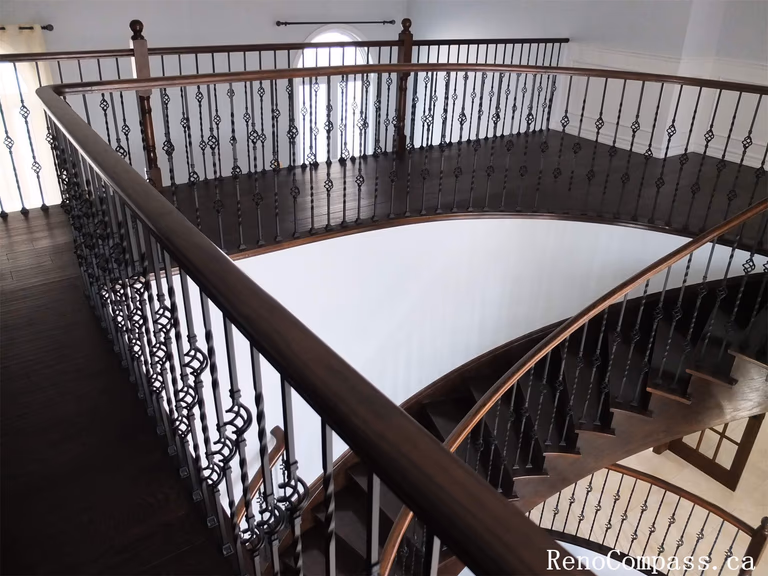 This Richmond Hill interior renovation features a spacious second-floor staircase landing with dark wood flooring and custom wrought iron railings. The updated staircase area enhances the home's architectural elegance while providing a bright and open transition between floors.