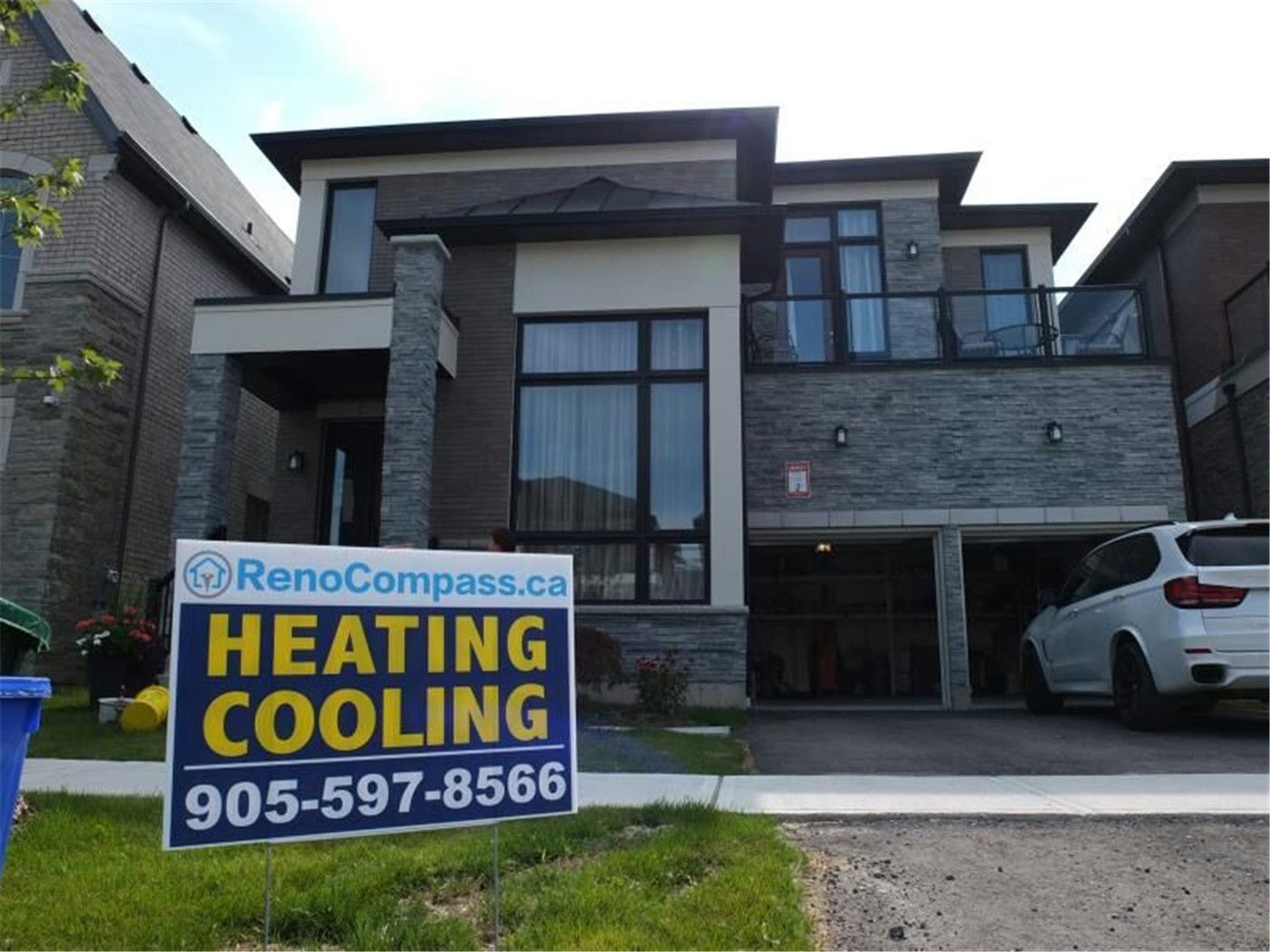 Professional outdoor air conditioner condenser installation by Reno Compass in Toronto. This energy-efficient HVAC unit is securely mounted on a raised stand with proper drainage and ventilation clearance, ensuring optimal cooling performance, durability, and safe operation for residential homes. Installed by licensed technicians for long-term reliability and comfort.
