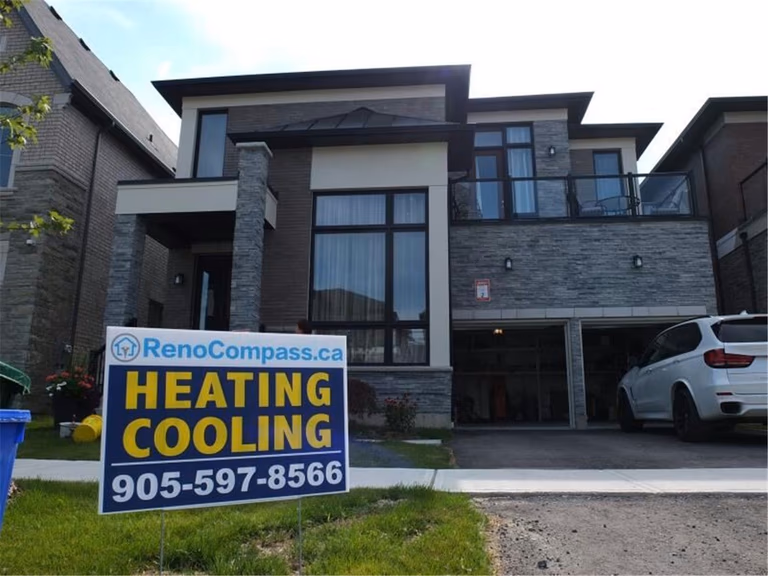 Professional outdoor air conditioner condenser installation by Reno Compass in Toronto. This energy-efficient HVAC unit is securely mounted on a raised stand with proper drainage and ventilation clearance, ensuring optimal cooling performance, durability, and safe operation for residential homes. Installed by licensed technicians for long-term reliability and comfort.